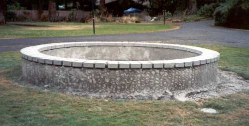  Solid concrete pavers are cemented on top of the wall and a pattern toweled into the outside wall. 