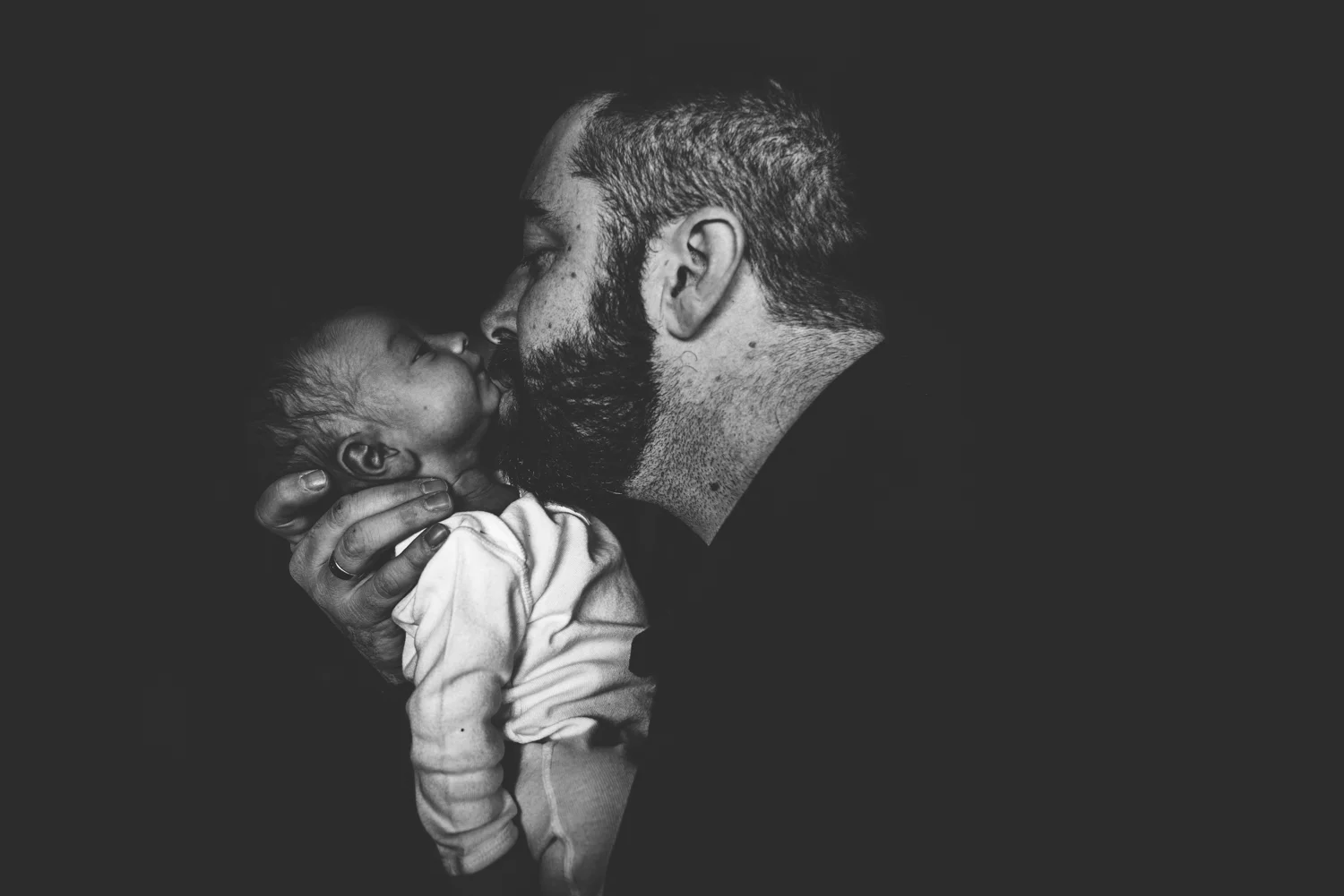 Dad snuggle with his newborn son during his newborn in home documentary session.