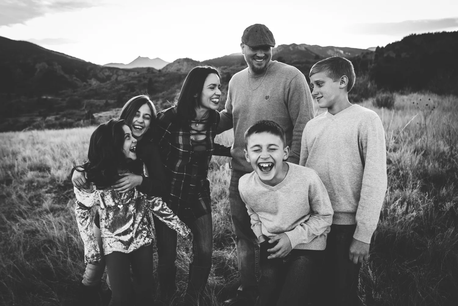 Large family laughs and plays during their family session in the foothills of Colorado Springs.