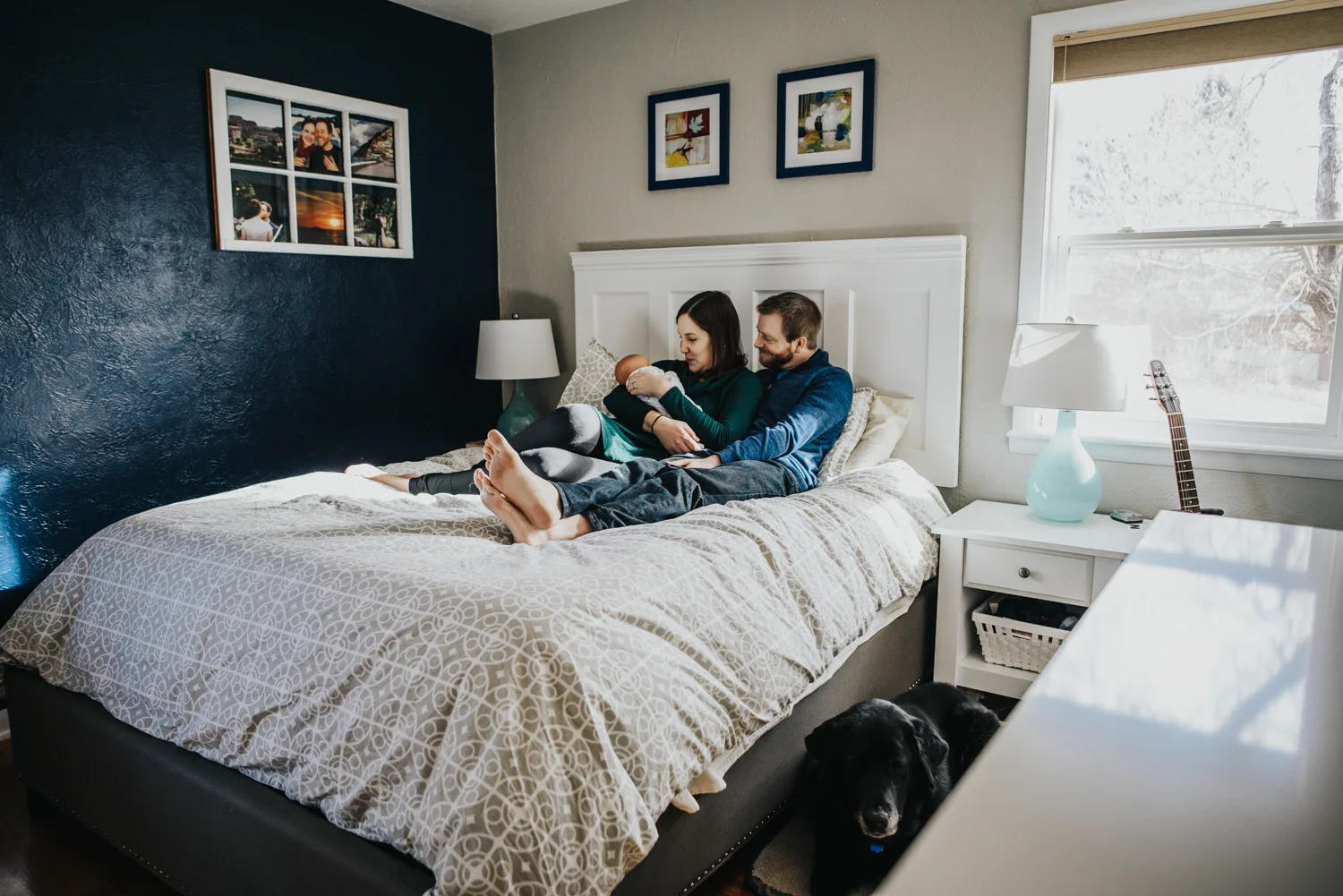 Family snuggles with their newborn on their bed during a documentary newborn session in their home.
