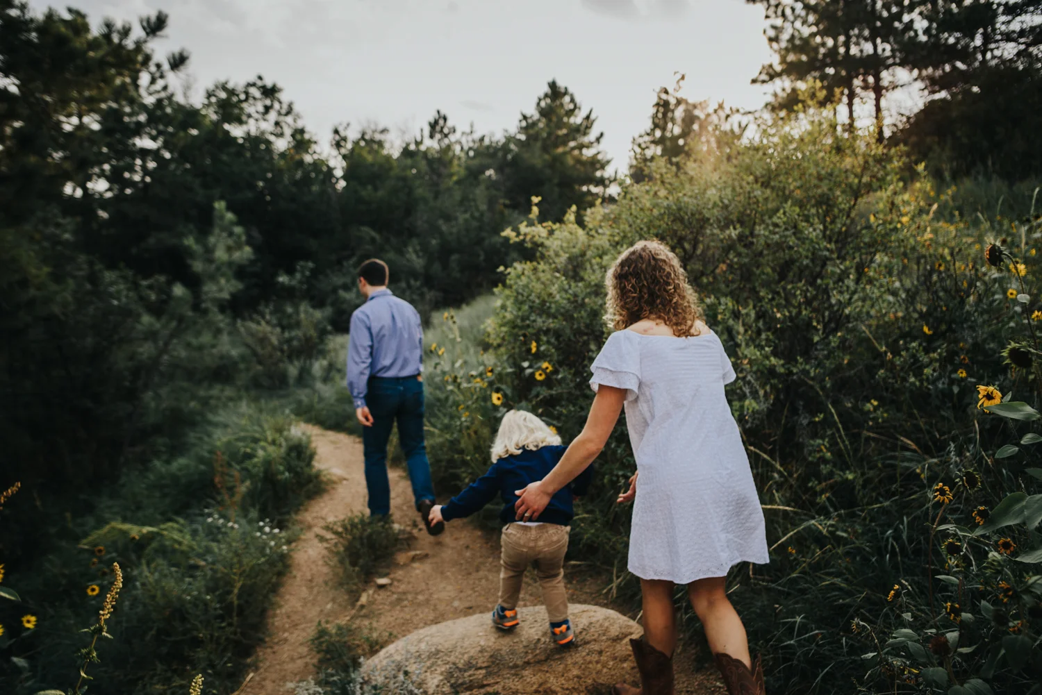 Family hikes in Colorado summer during family photo session in Colorado Springs open space.