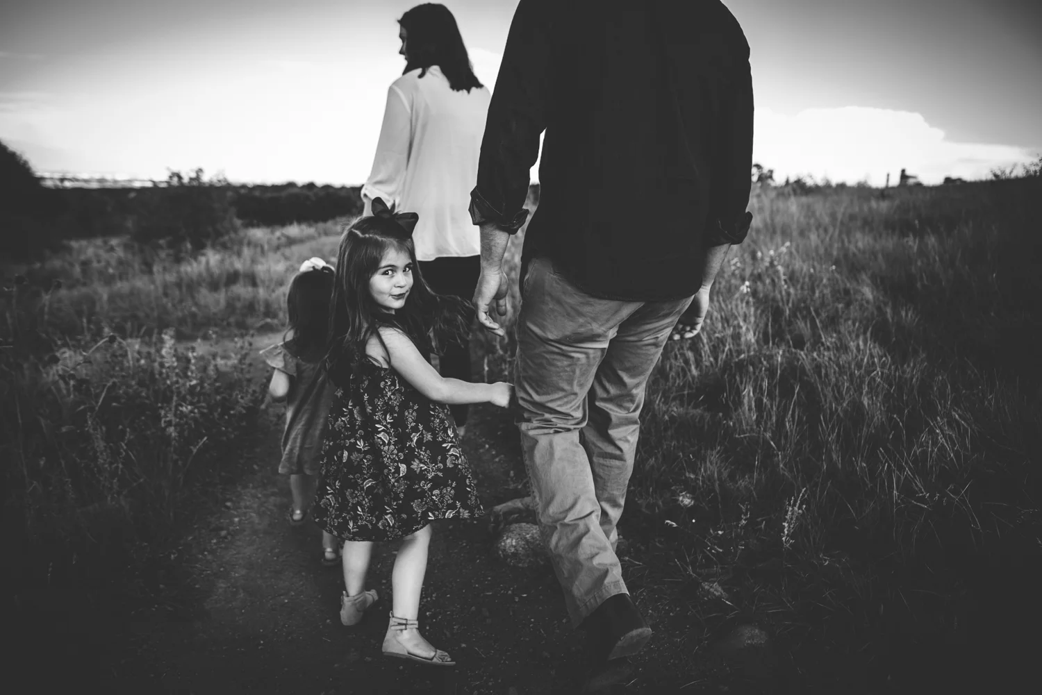 Military family of four hikes in Colorado Springs open space during family photography session.