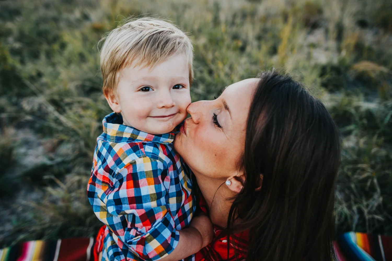 Little boy snuggles with his mom during a family session in Colorado Springs open space.