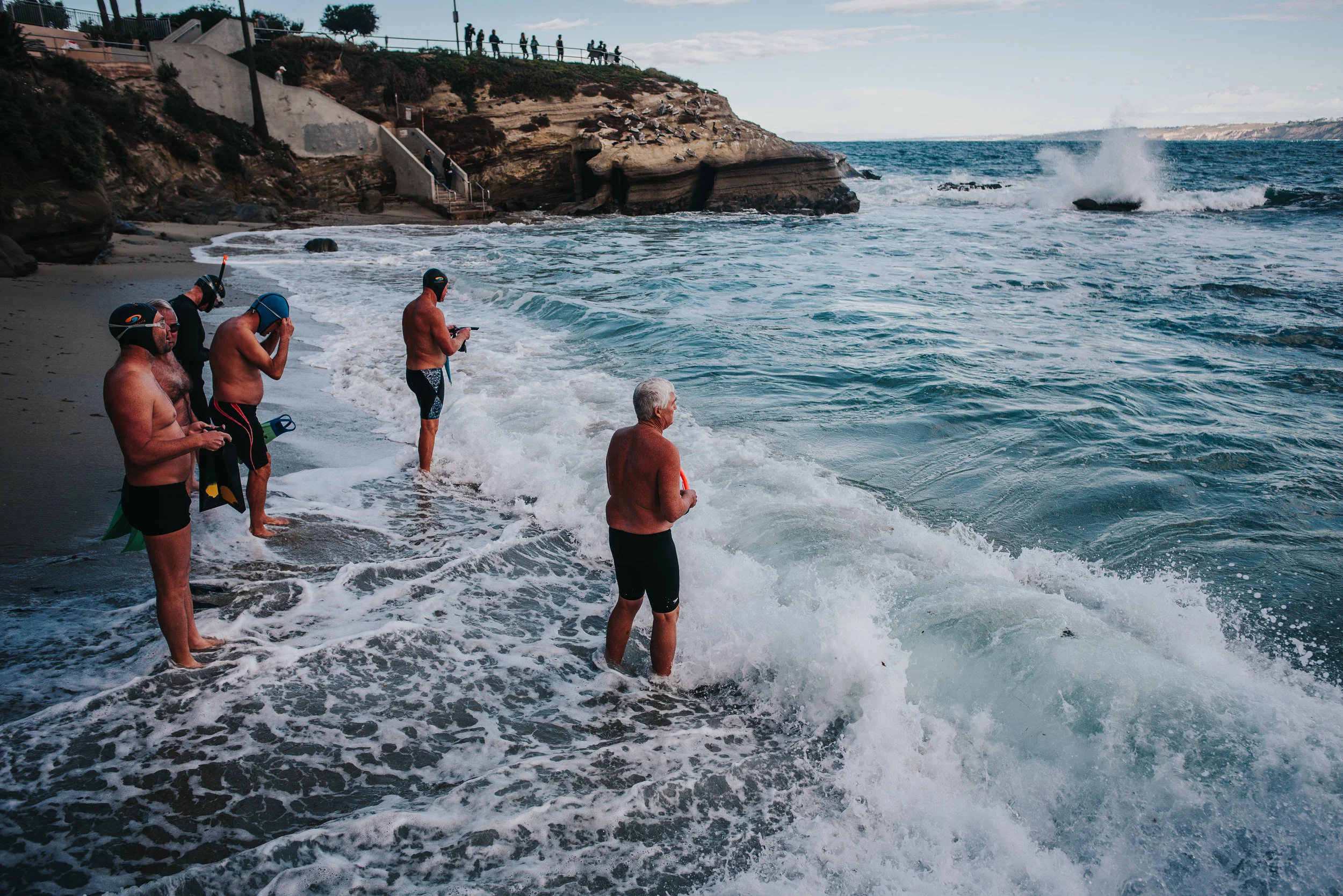 Older men brace the fierce California surf.