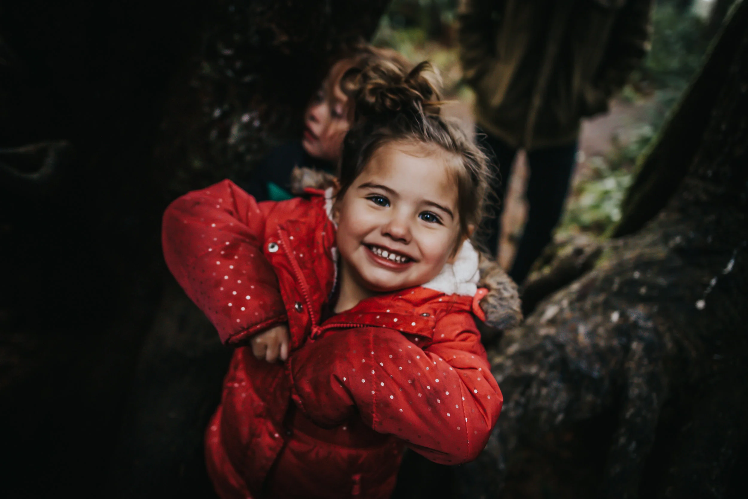 Little girl smiles and is enjoy her time in a tree in Oregon at Oswald West State Park.