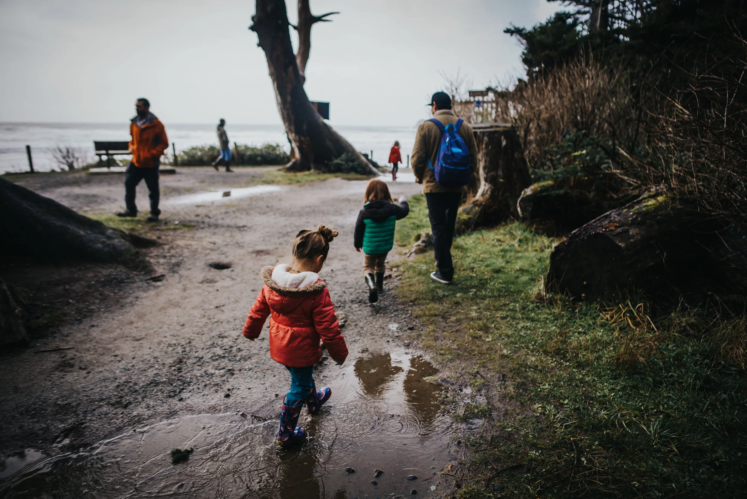 Children hike with their dad on the coast of the Pacific Ocean at Oswald West State Park.