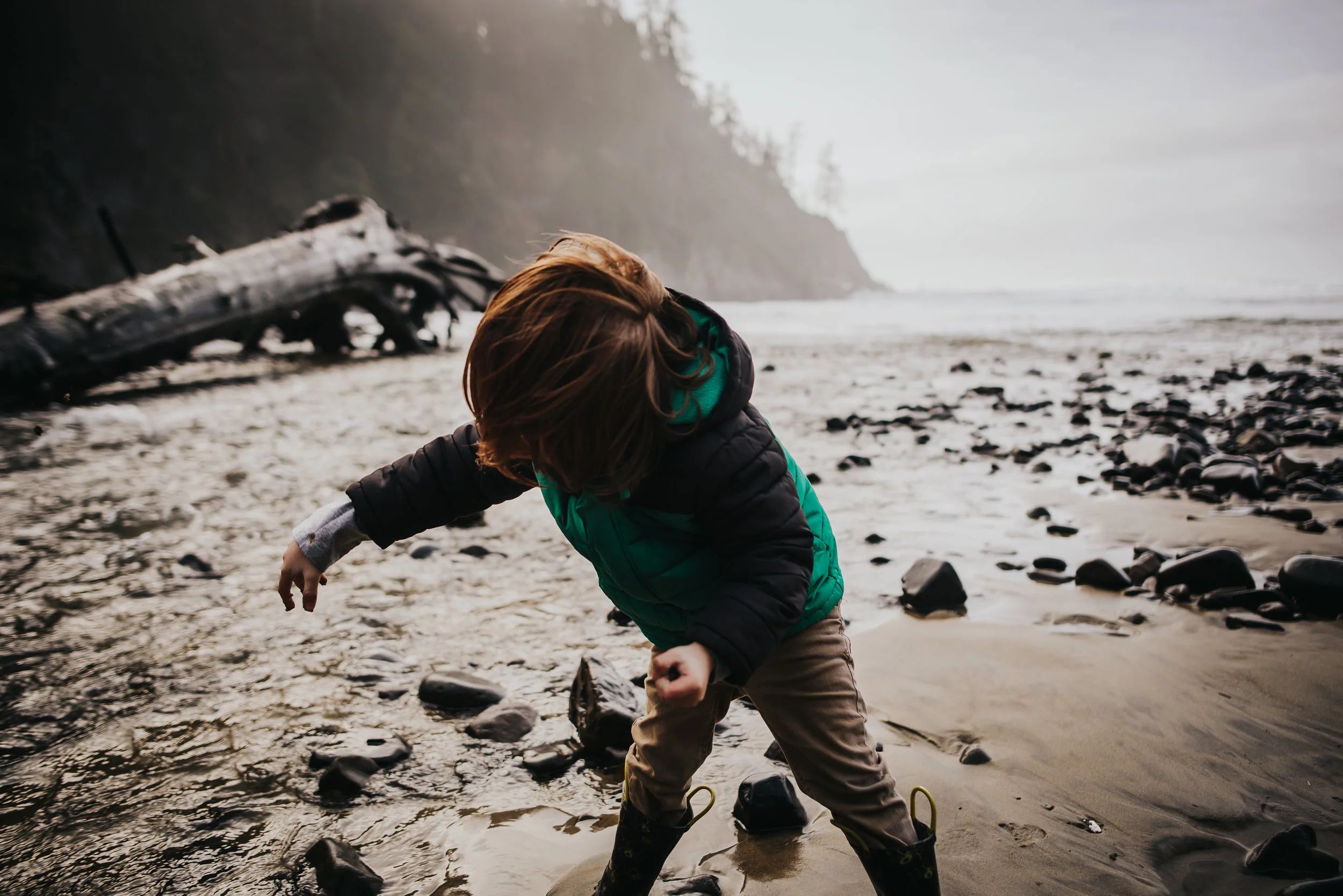 Little boy enjoys playing in the water near the Pacific Coast in Oswald State Park.