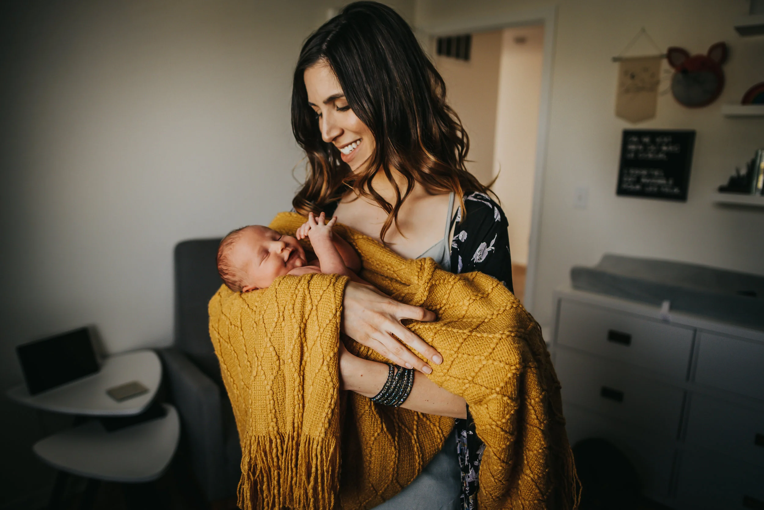 Mother holds her newborn son in his nursery in Colorado Springs.