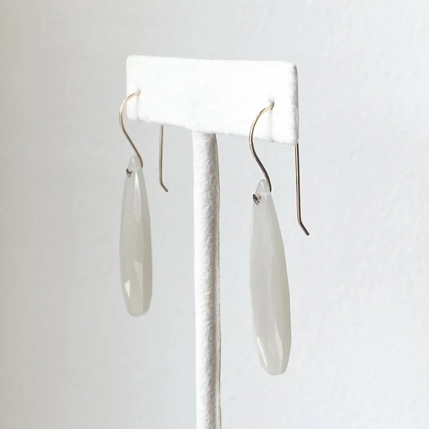 long faceted teardrop moonstone drop earrings with gold filled findings made by Kim Drosdick shown on earring stand side view