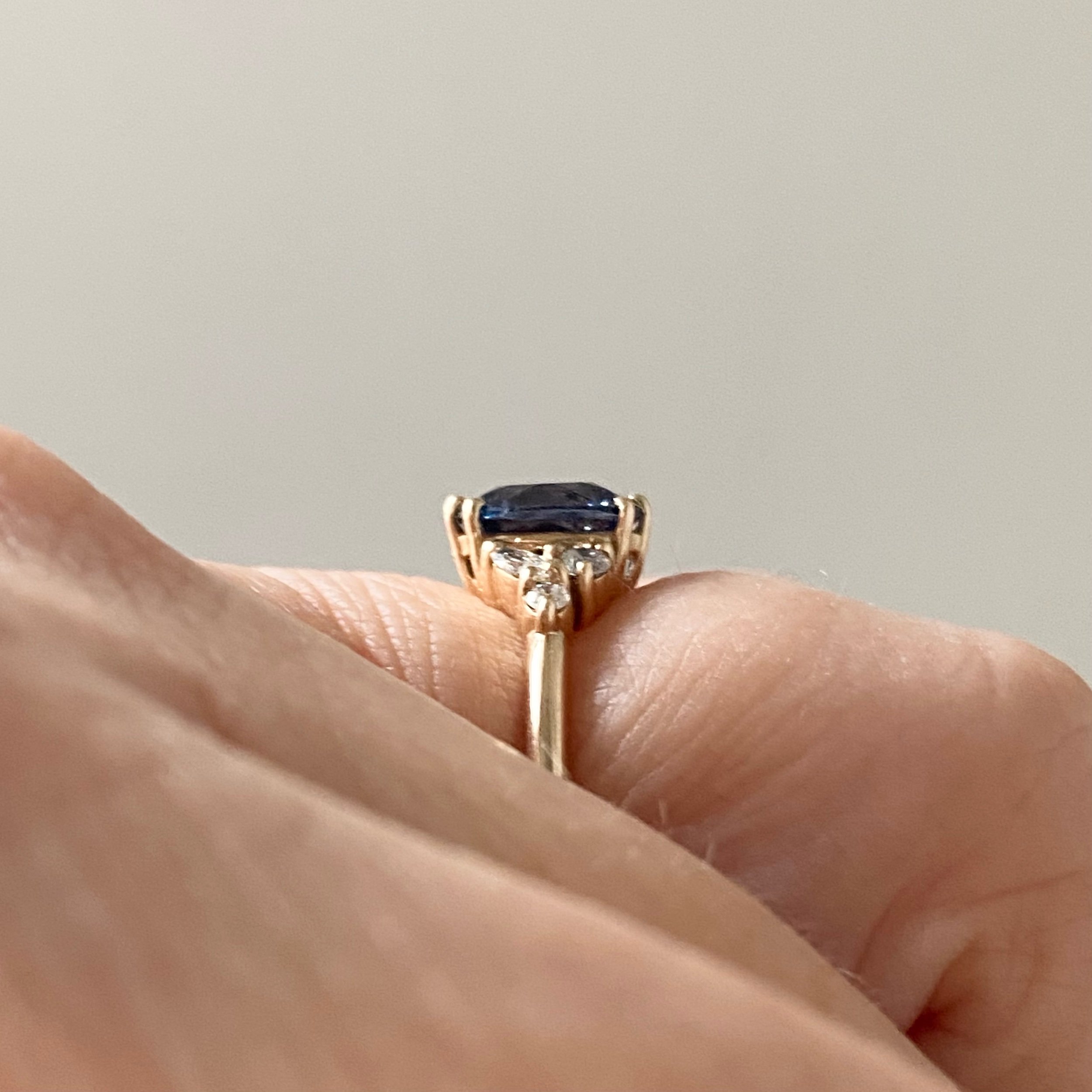 oval blue violet spinel diamond accents mirrored side clusters 14k yellow gold engagement ring side view Kim Drosdick Jewellery