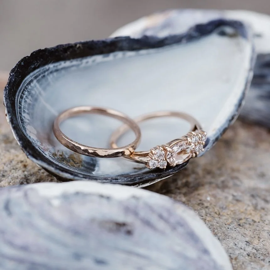 east west claw set oval morganite with mixed size round mirrored canadian diamond clusters shown on hand and raised to allows future flush wedding ring 14k rose gold Kim Drosdick Jewellery Toronto