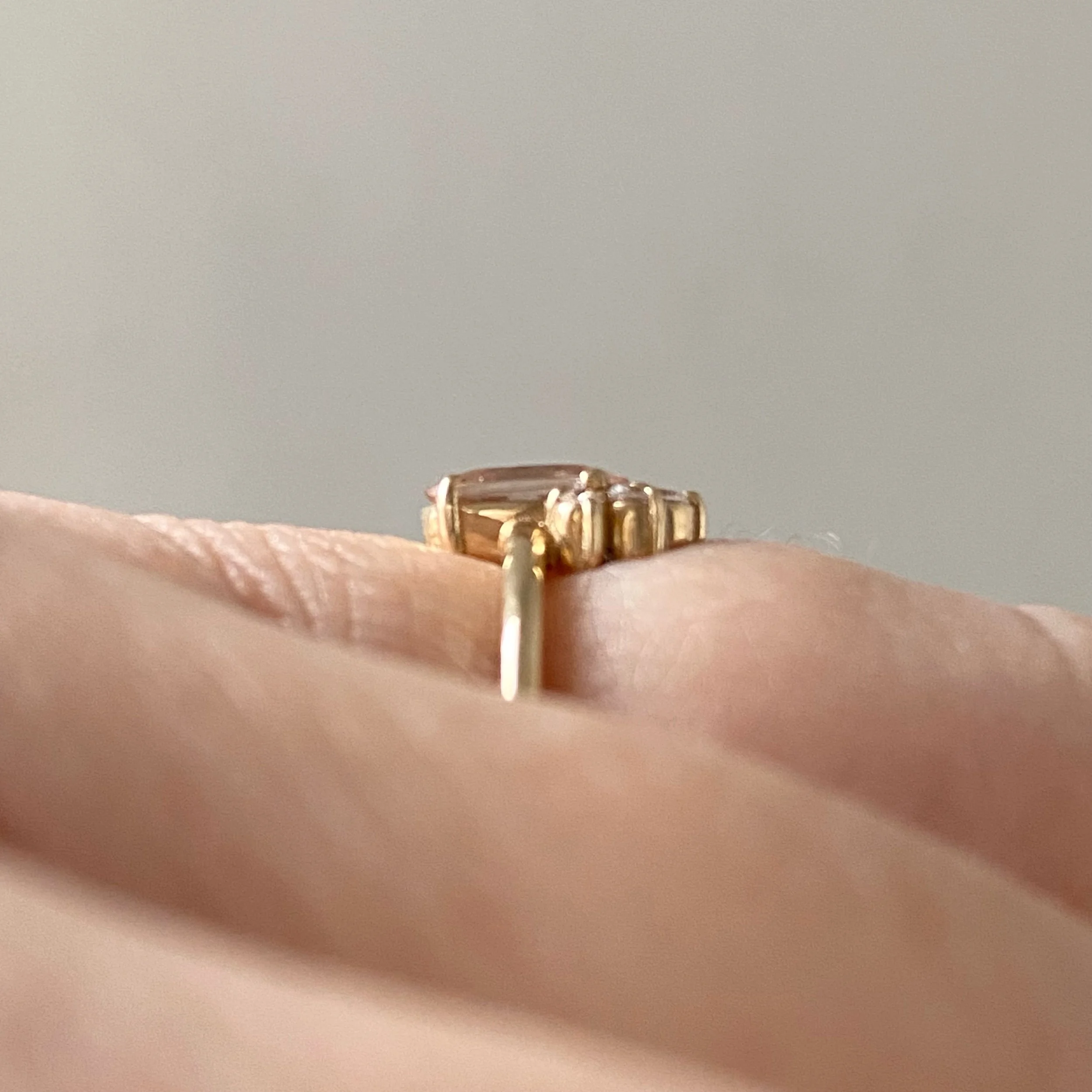 peachy pink oval morganite with little crown of Canadian diamonds claw set in 14k yellow gold narrow rounded band side view Kim Drosdick Jewellery Toronto