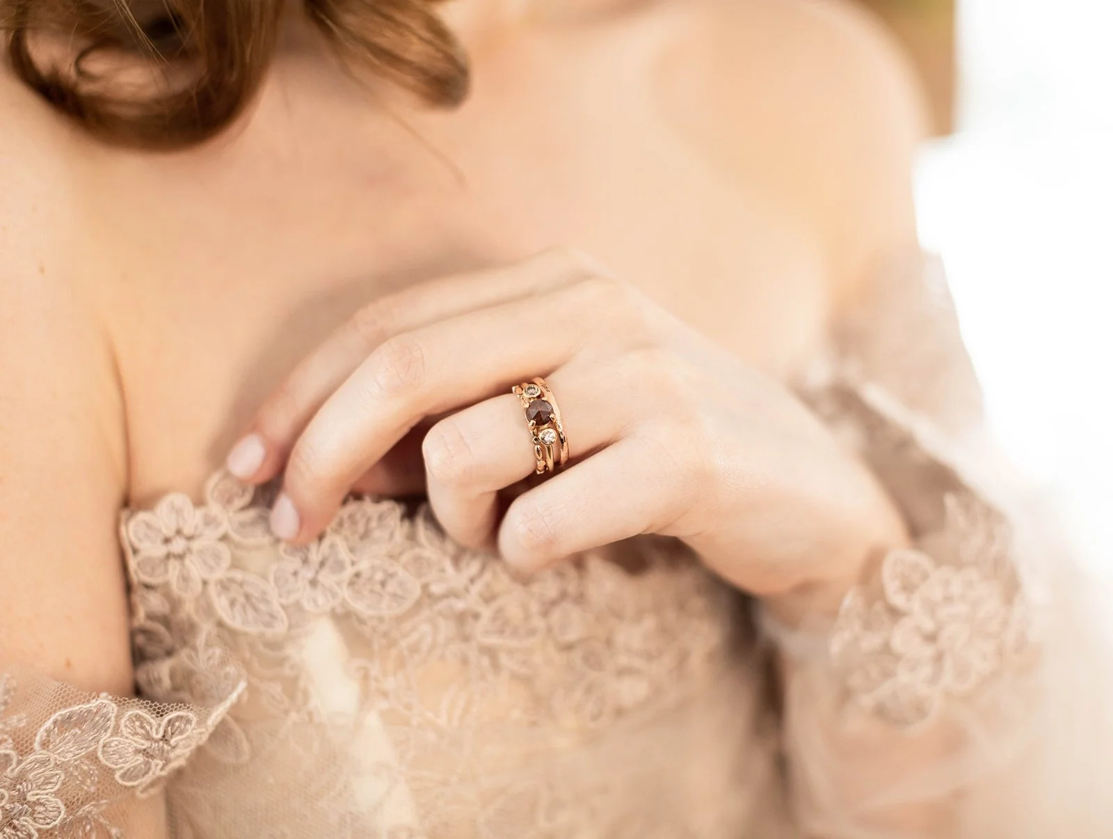 round deep red rose cut claw set diamond flanked by bezel set champagne brilliant cut diamonds 14k yellow gold on model with stacking wedding bands Kim Drosdick Jewellery Toronto