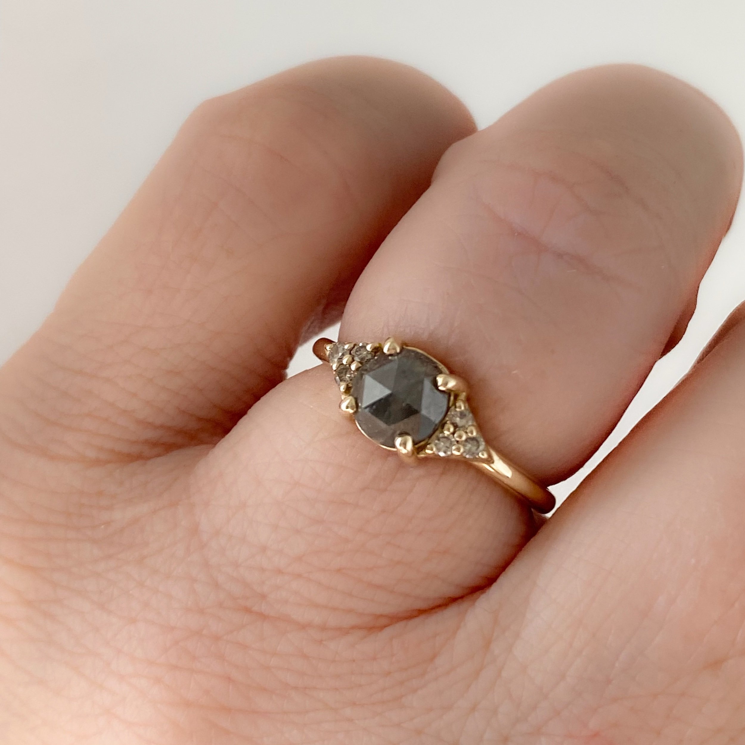 dark grey rose cut diamond engagement ring with diamond trio triangle sides 14k yellow gold front view on hand Kim Drosdick Jewellery Toronto