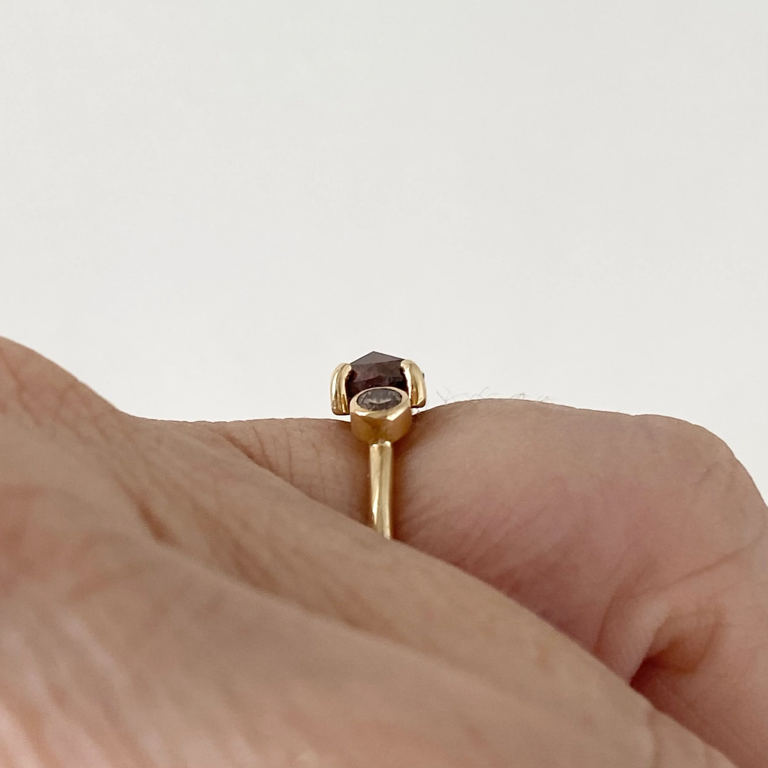 dark grey rose cut diamond engagement ring with diamond trio triangle sides 14k yellow gold side finger view on hand Kim Drosdick Jewellery Toronto