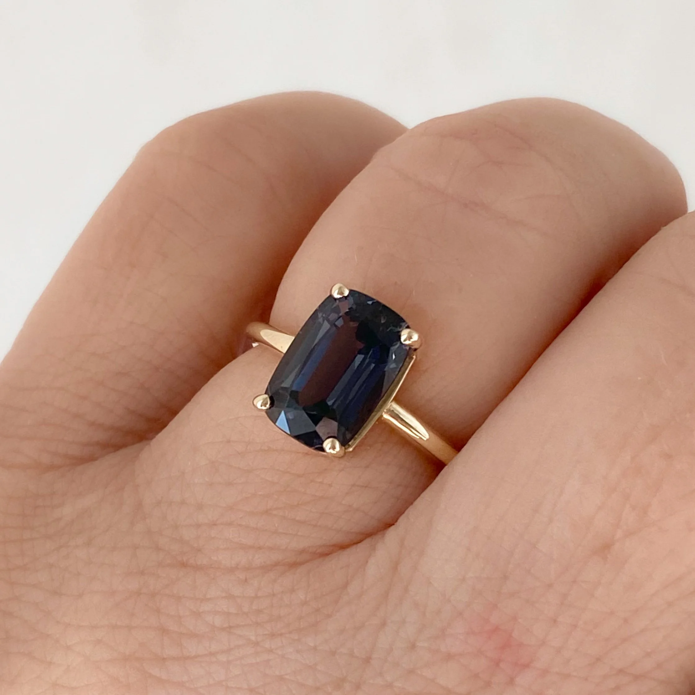 dark blue cushion cut spinel solitaire engagement ring 14ky recycled gold on hand Kim Drosdick Toronto