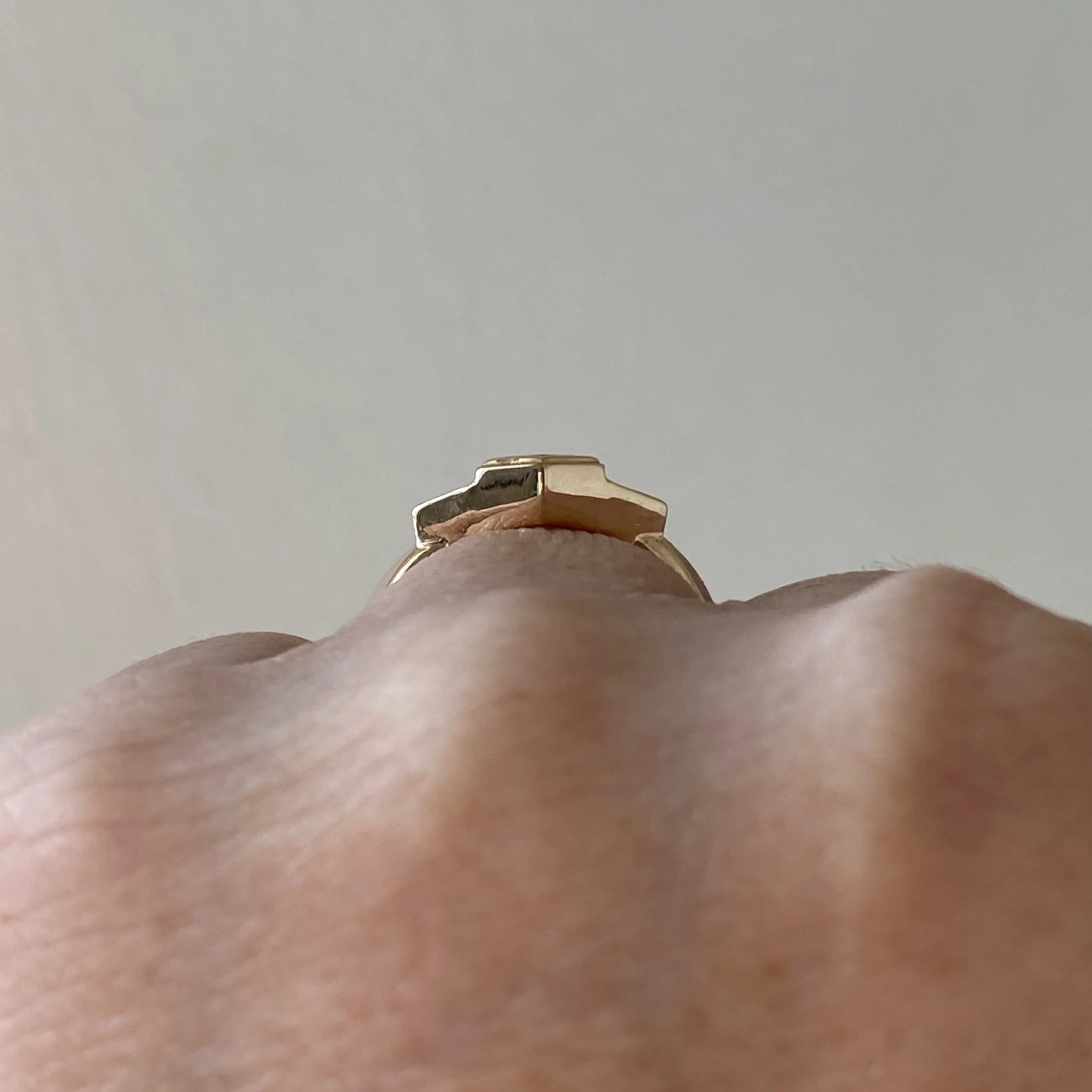 dark teak hexagonal spinel 3 stone engagement ring bezel settings rounded narrow band 14k yellow gold through finger view on hand Kim Drosdick Jewellery Toronto
