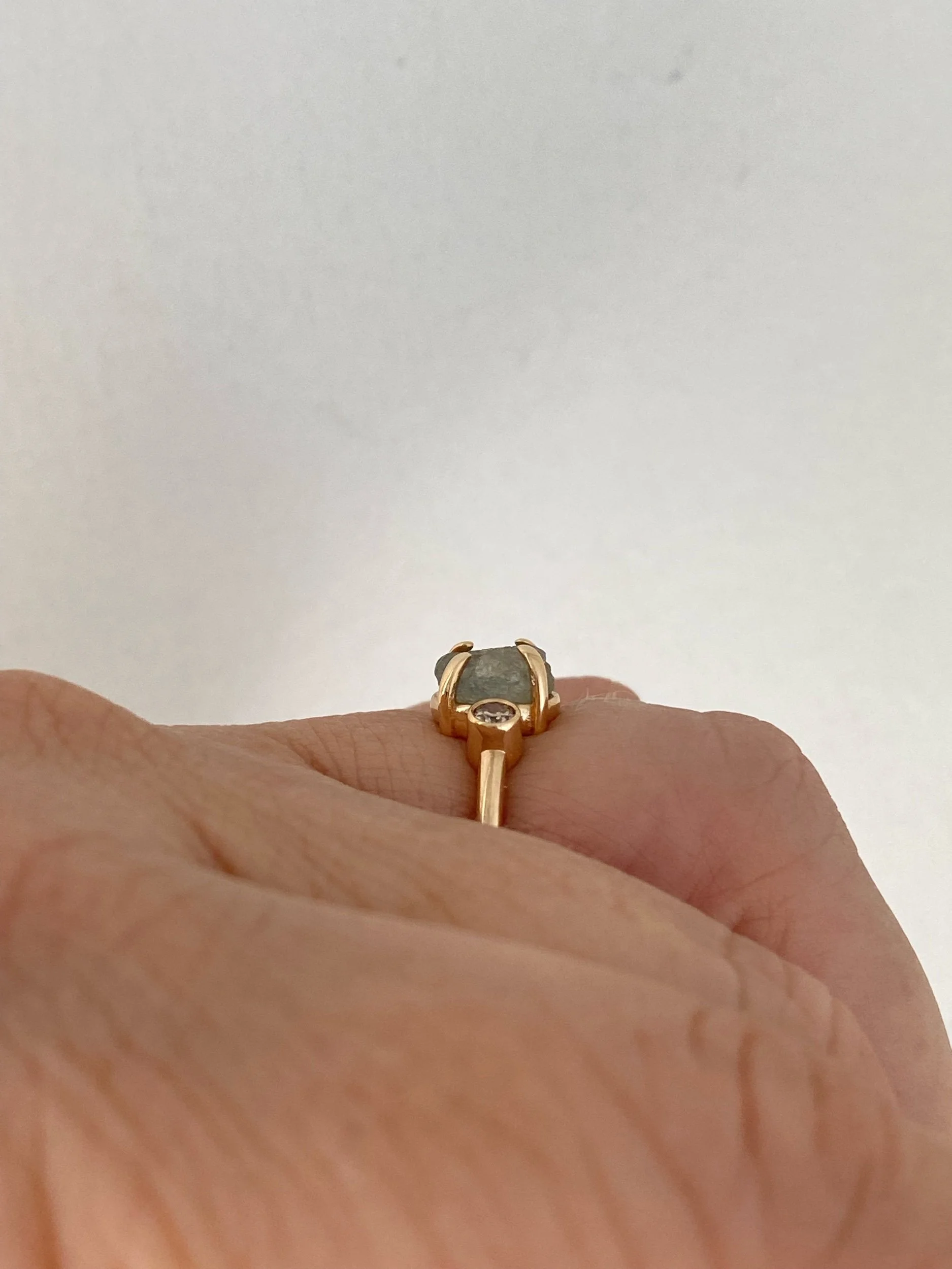 round Montana minty blue green claw set engagement ring with side bezel set champagne diamonds 14k yellow gold side view on hand Kim Drosdick Jewellery Toronto