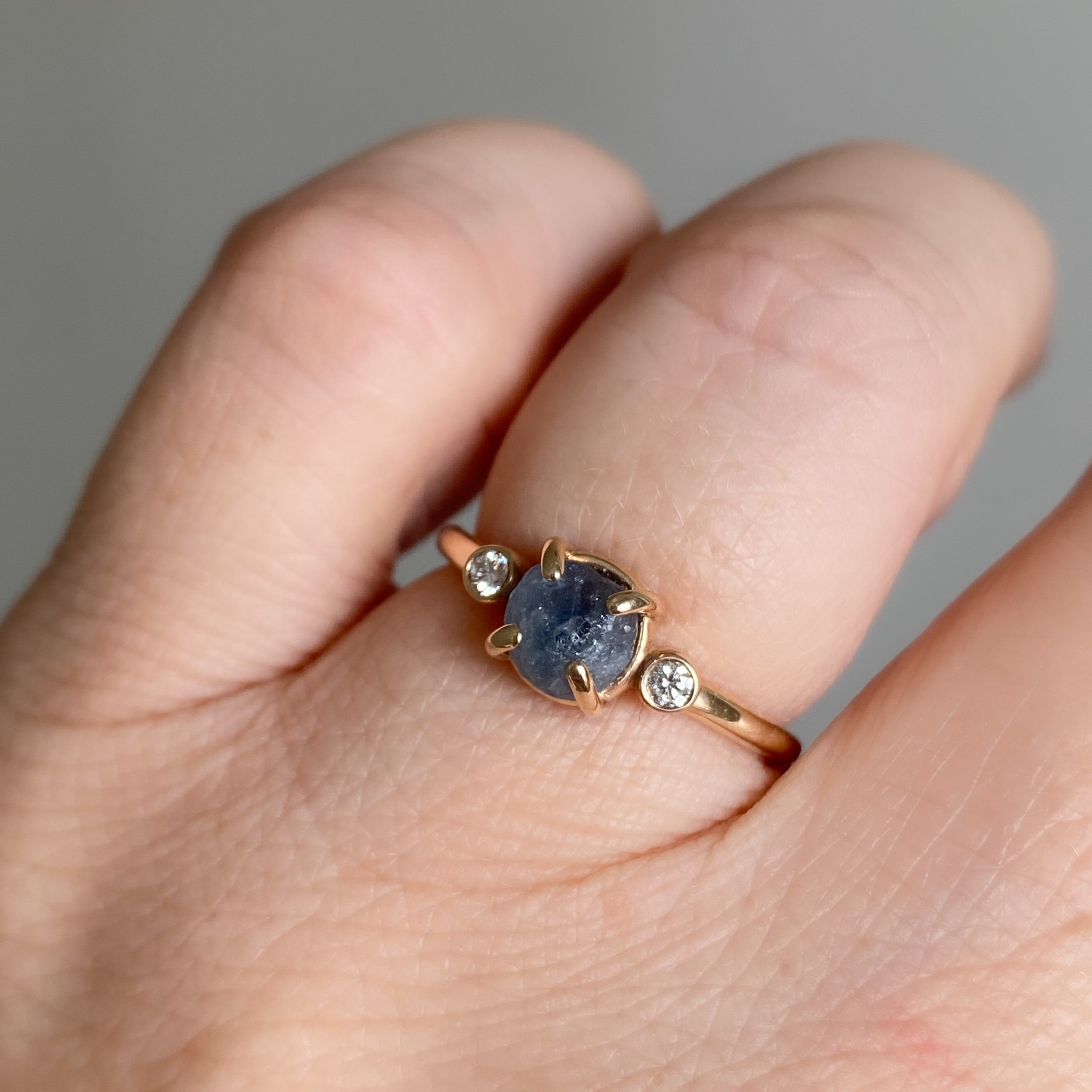 rough blue montana engagement ring claw set and bezel set side canadian diamonds 14k yellow gold on hand Kim Drosdick Jewellery Toronto