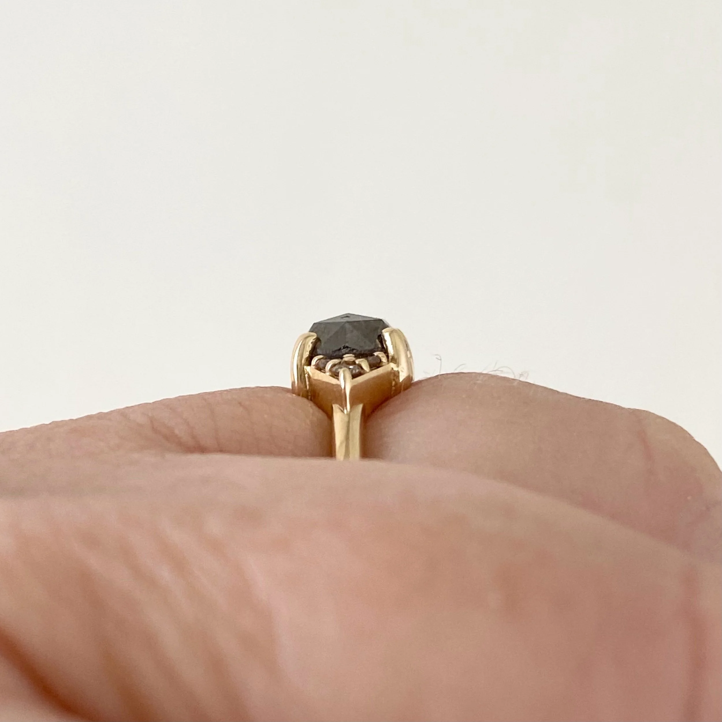 dark grey rose cut diamond engagement ring with diamond trio triangle sides 14k yellow gold front view on hand Kim Drosdick Jewellery Toronto on hand side view