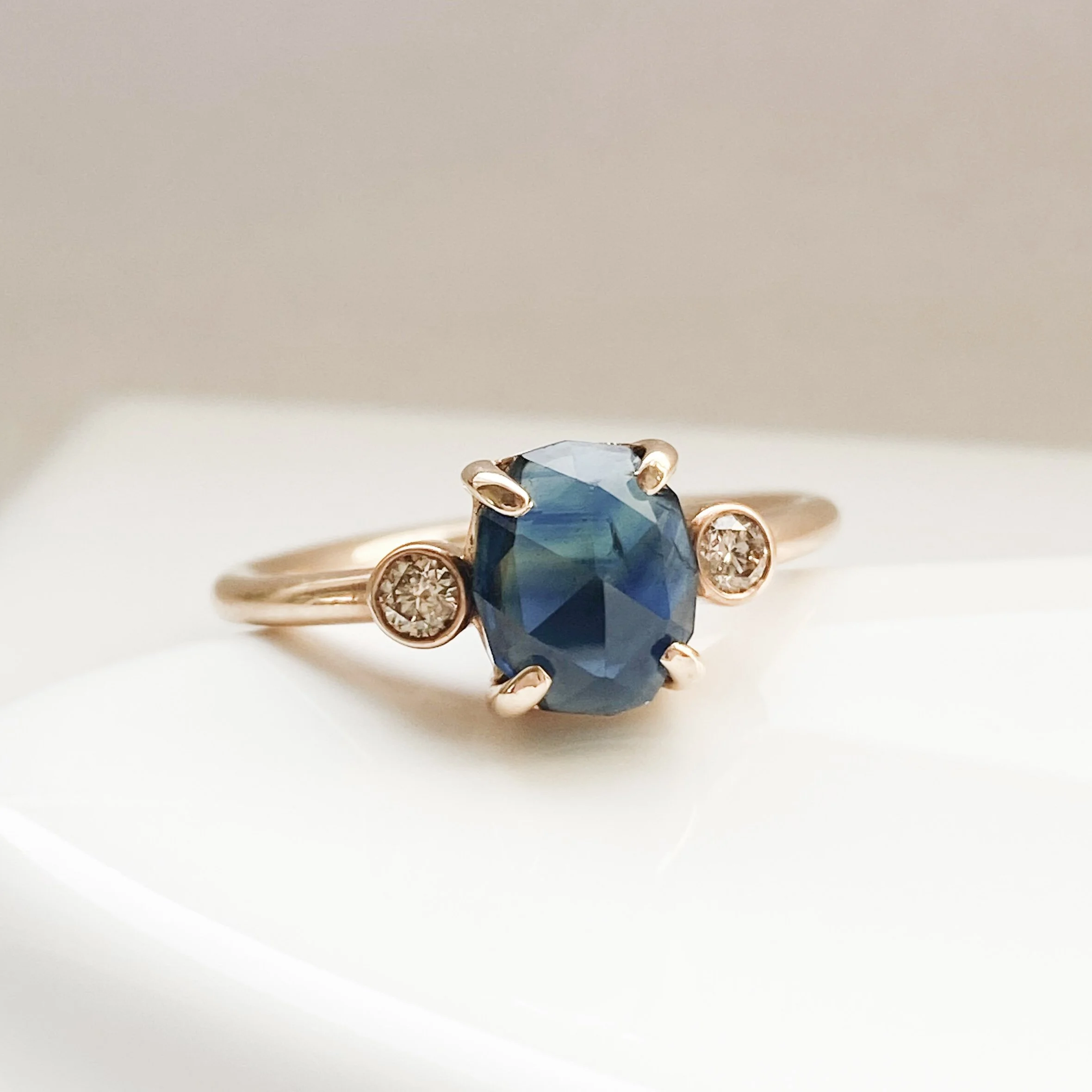 rose cut blue oval sapphire 3-stone champagne diamond alternative engagement ring 14k yellow gold bezel set claw set rounded band Kim Drosdick Jewellery Toronto