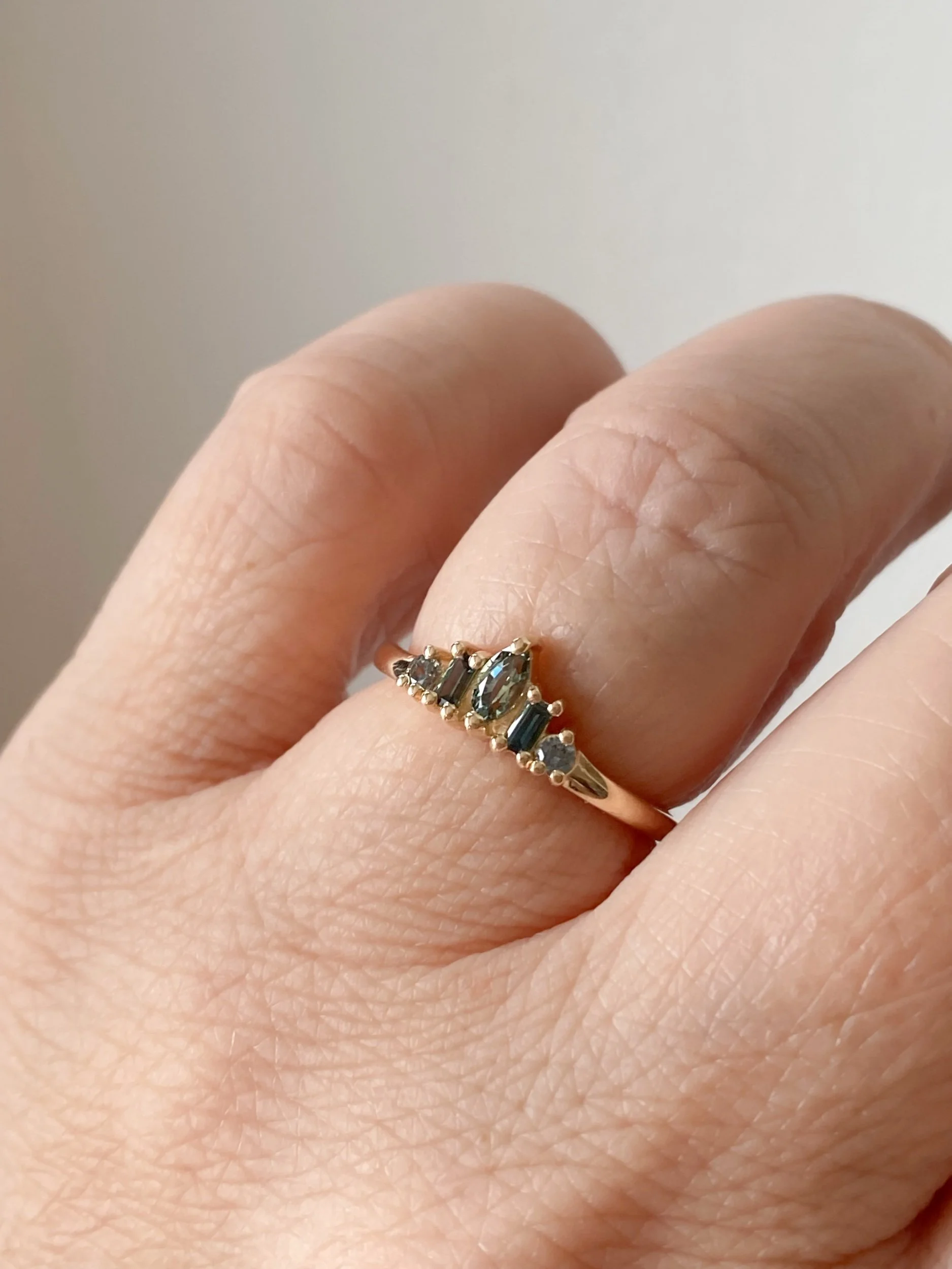 green sapphire mixed cut tiara recycled 14k yellow gold engagement wedding ring on hand kim drosdick toronto
