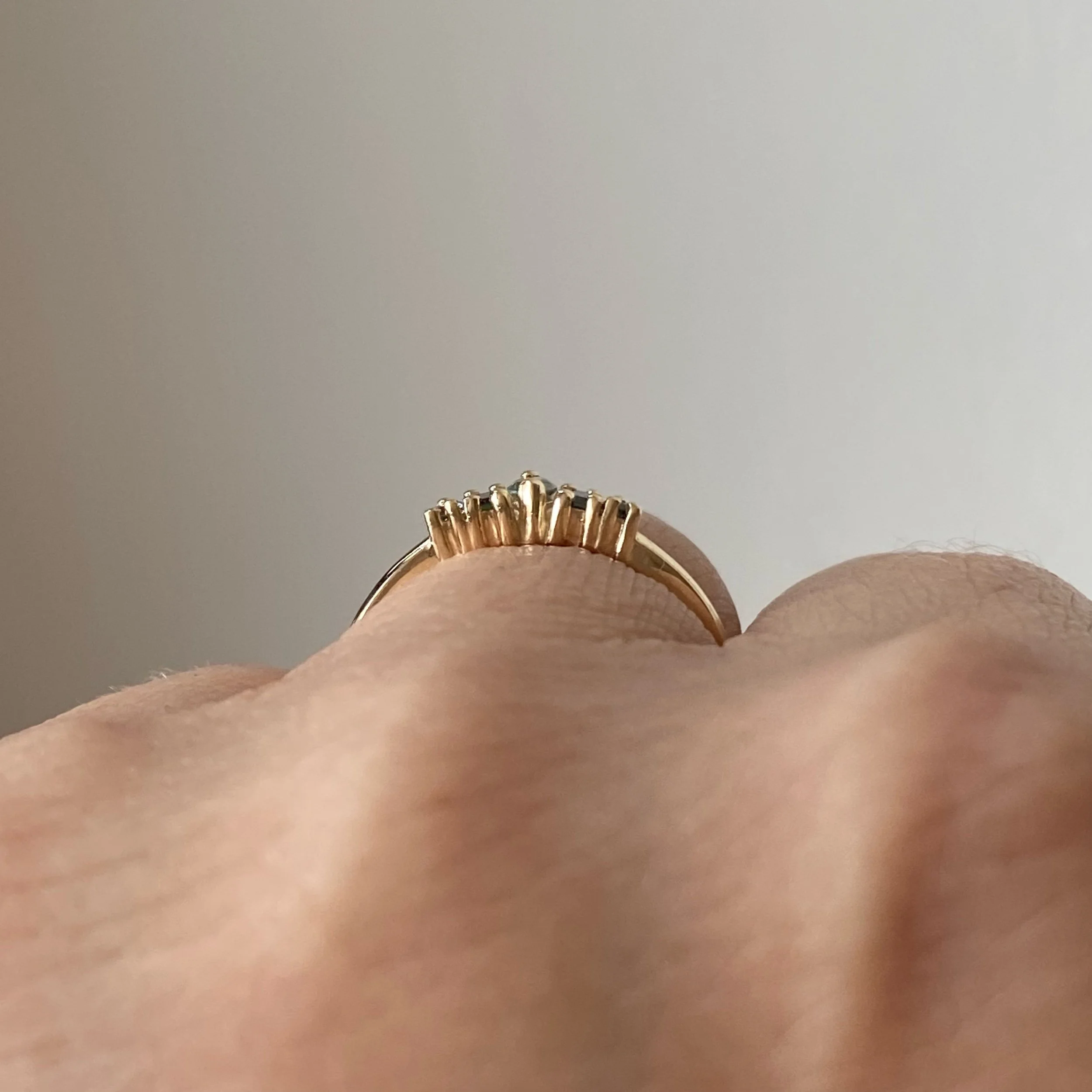 green sapphire mixed cut tiara recycled 14k yellow gold engagement wedding ring through finger view on hand kim drosdick toronto