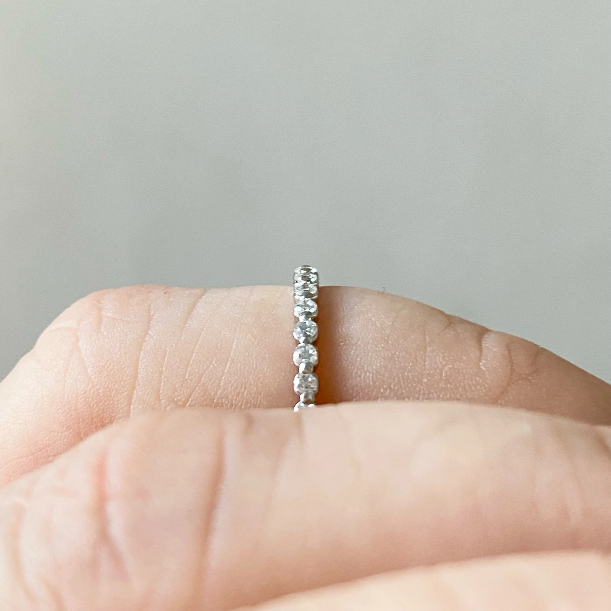 lab diamond and platinum eternity wedding stacking ring shared single claw on hand side view