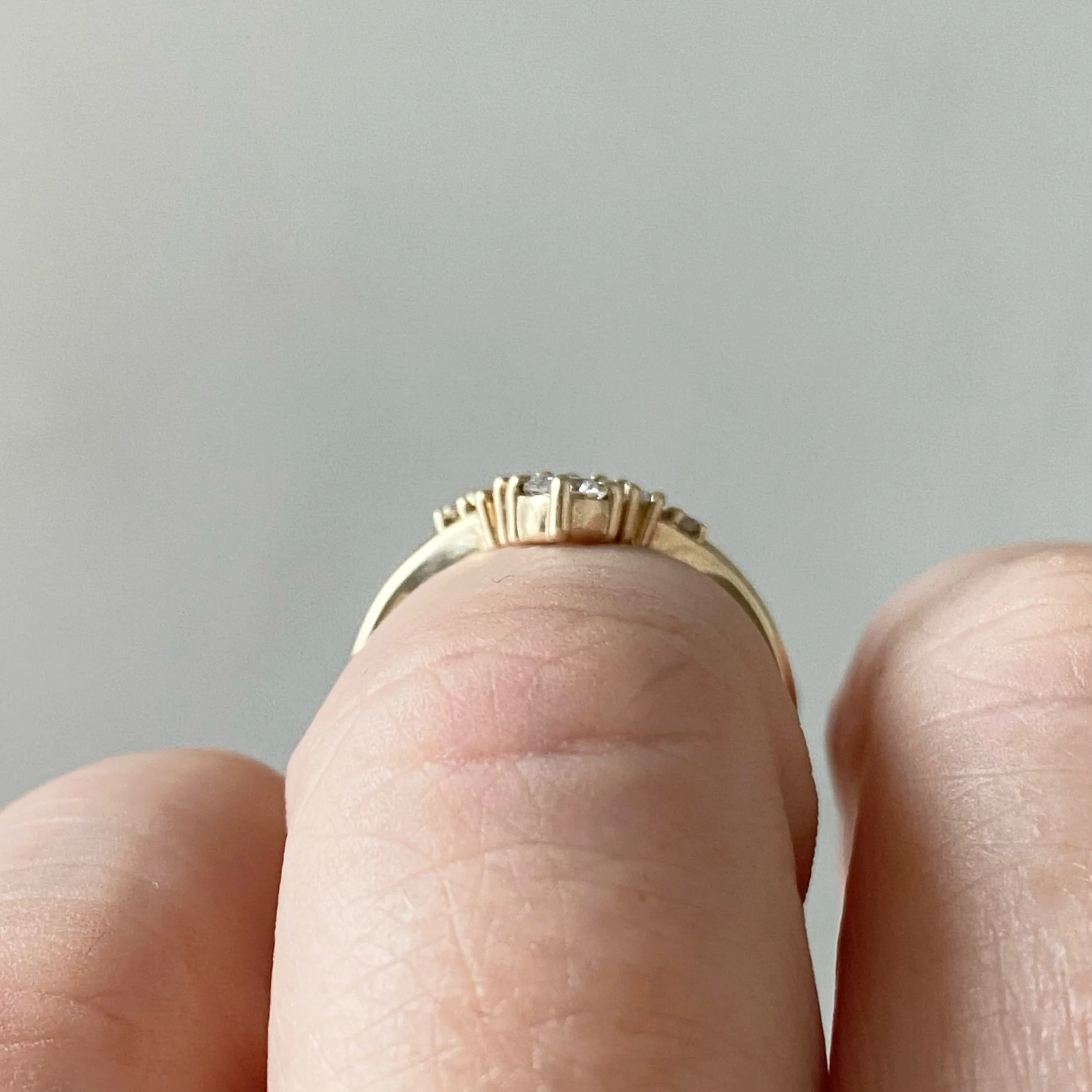 graduated diamond contour band claw set wedding band in 14k recycled yellow gold on hand side view