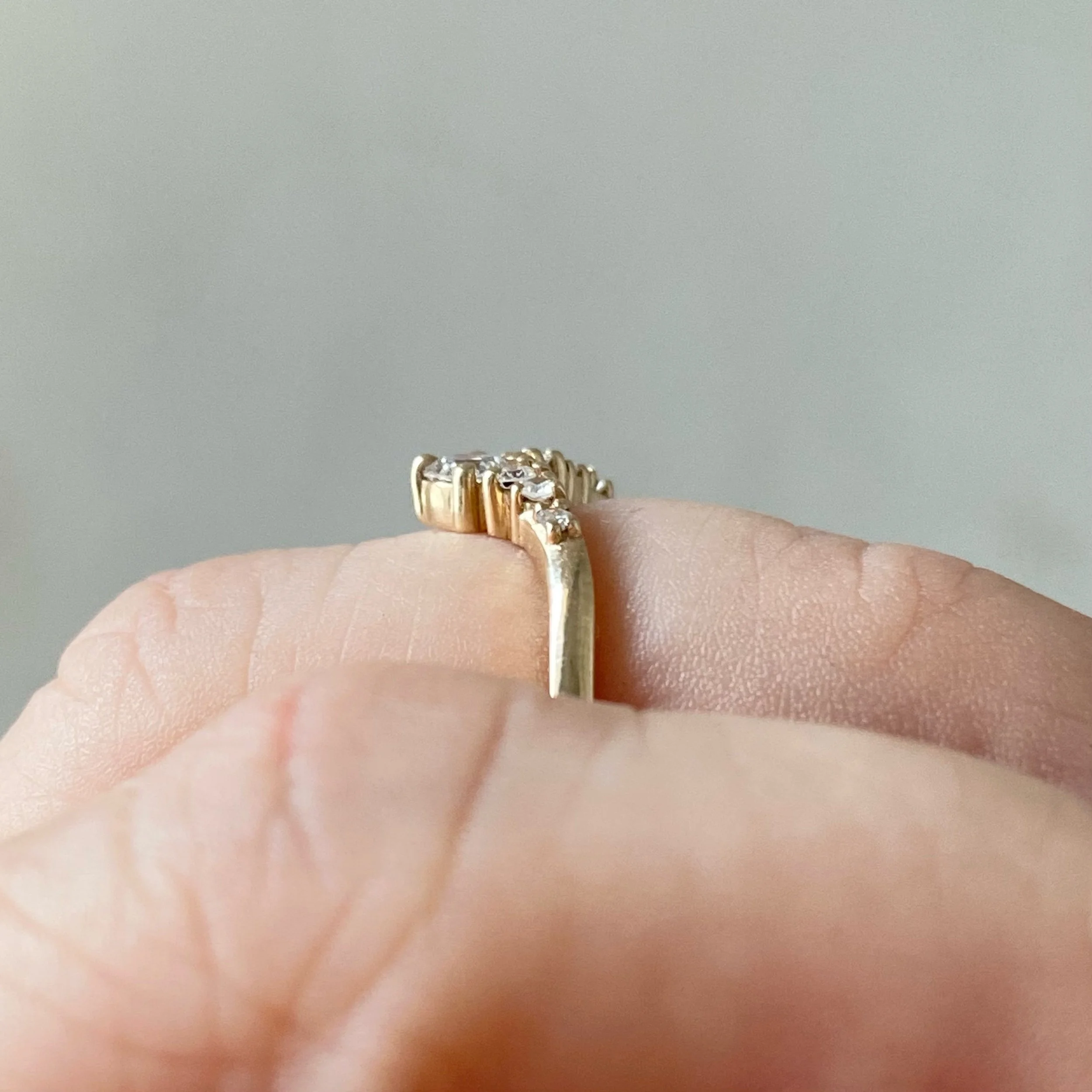 graduated diamond contour band claw set wedding band in 14k recycled yellow gold on hand side view
