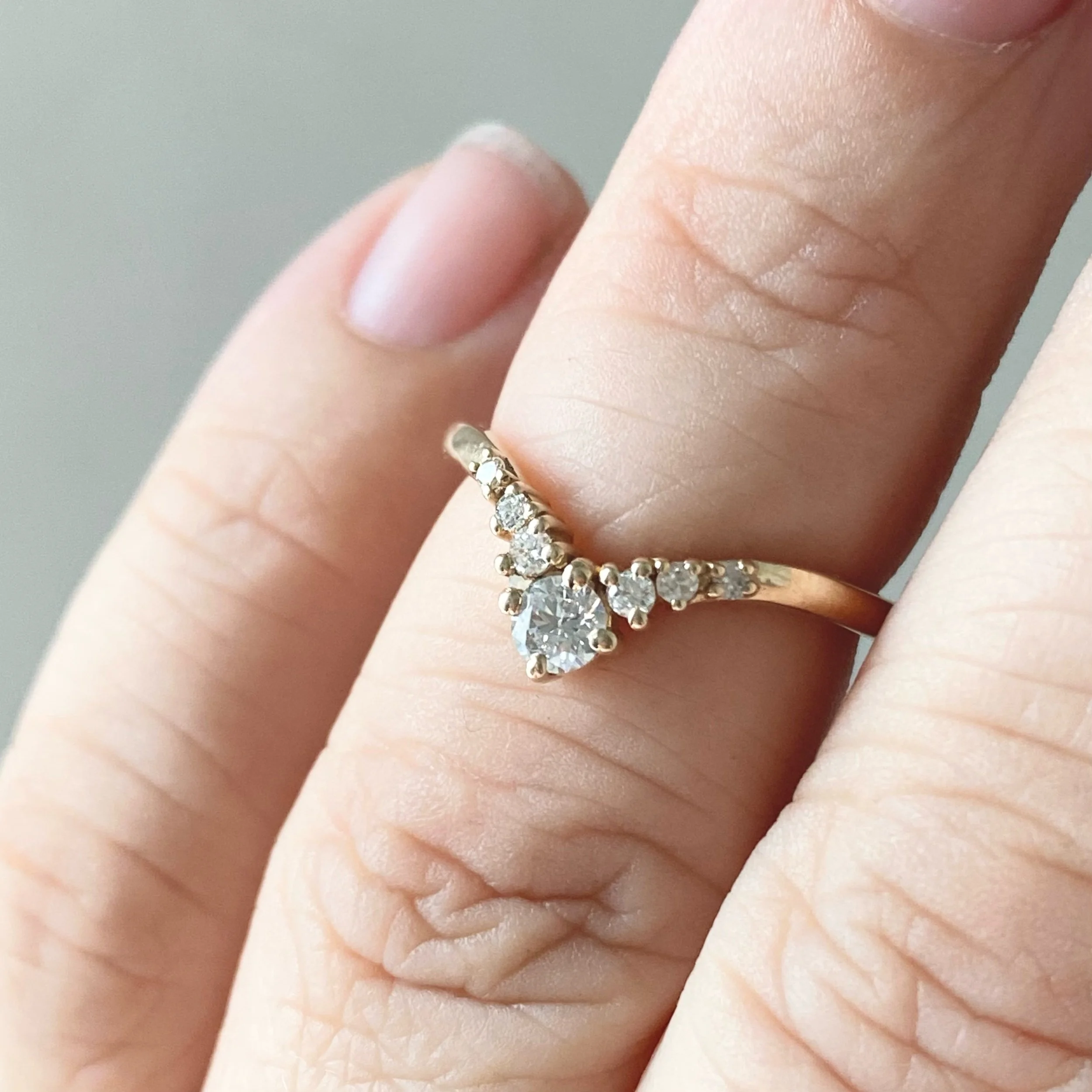 graduated diamond contour band claw set wedding band in 14k recycled yellow gold on hand