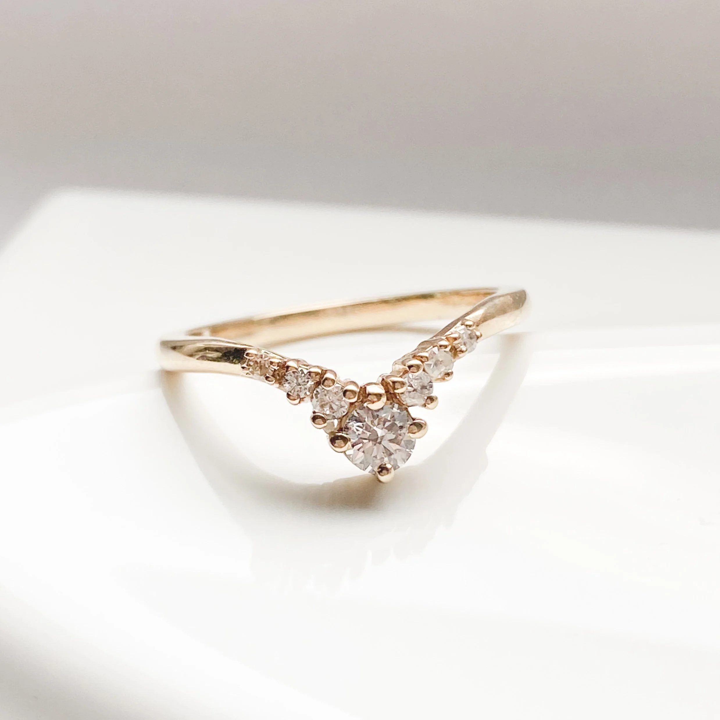 graduated diamond contour band claw set wedding band in 14k recycled yellow gold on prop