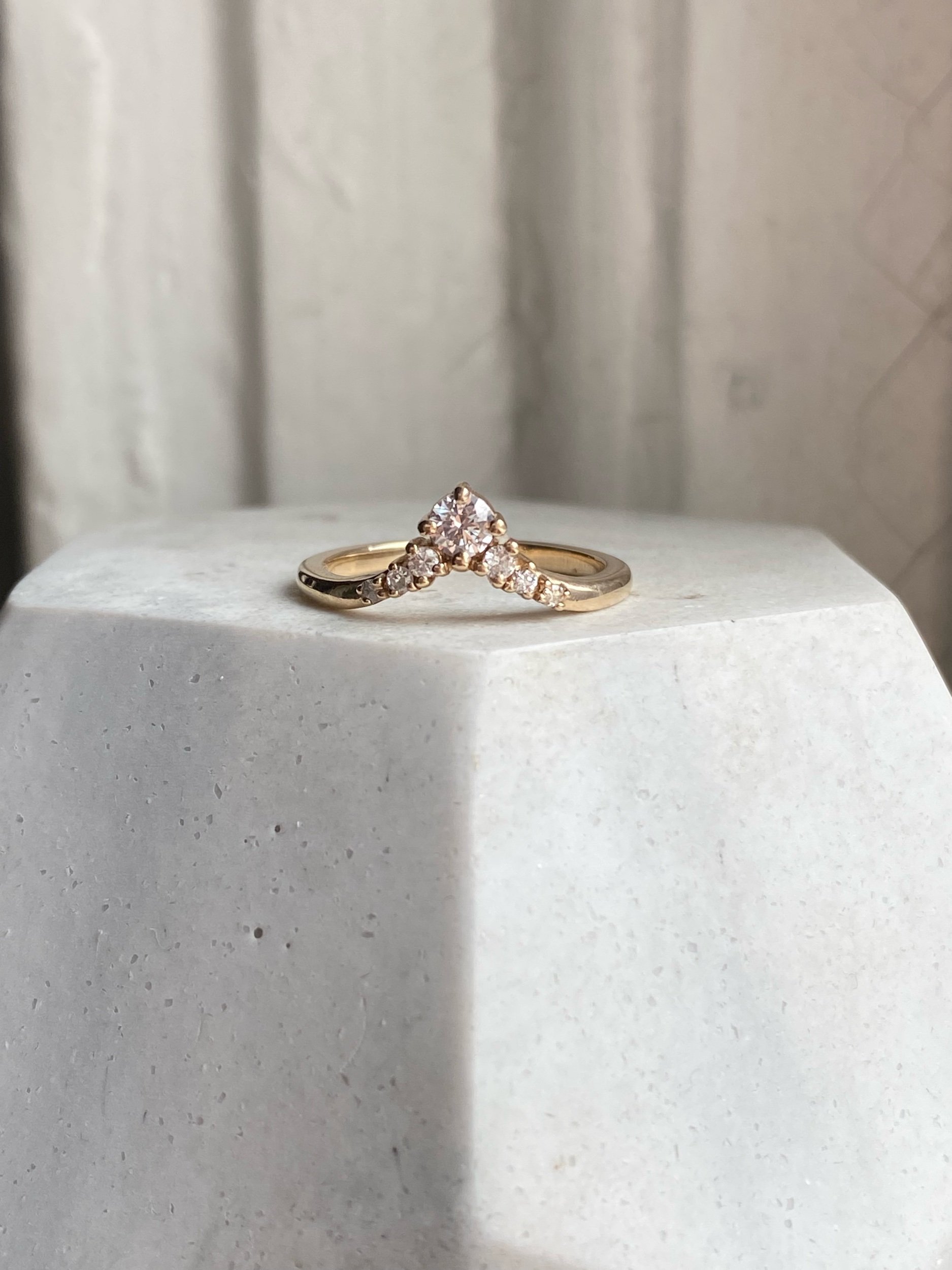 5 stone diamond wedding band 14k yellow gold  contour round brilliant cut colourless Kim Drosdick Jewellery Toronto in hand with matching engagement ring on prop