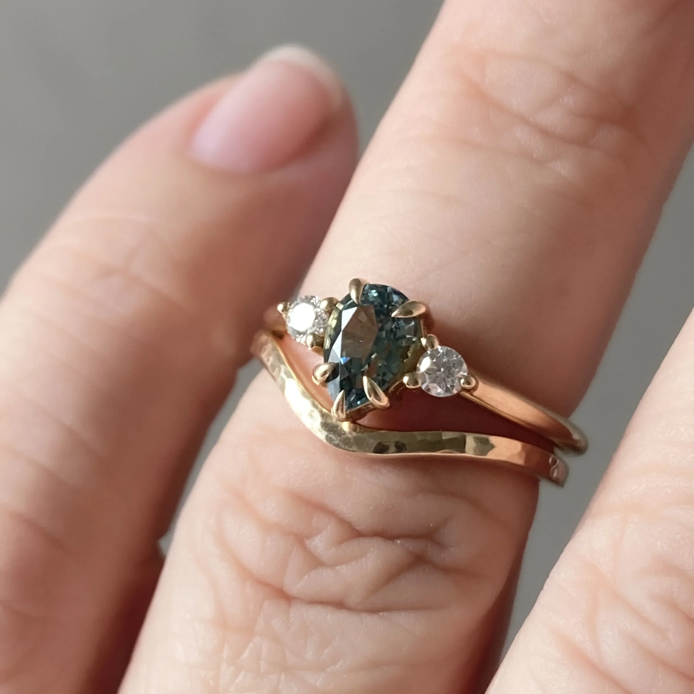 narrow hammered recycled 14k yellow gold contour wedding ring stacking band polished on hand with teal pear sapphire and diamond 3 stone engagement ring boho organic vintage kim drosdick toronto