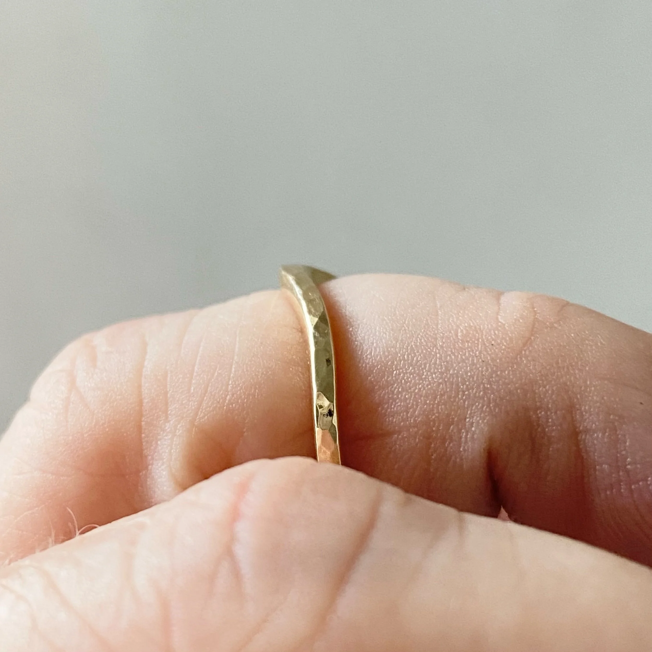 narrow hammered recycled 14k yellow gold contour wedding ring stacking band polished on hand side view boho organic vintage kim drosdick toronto