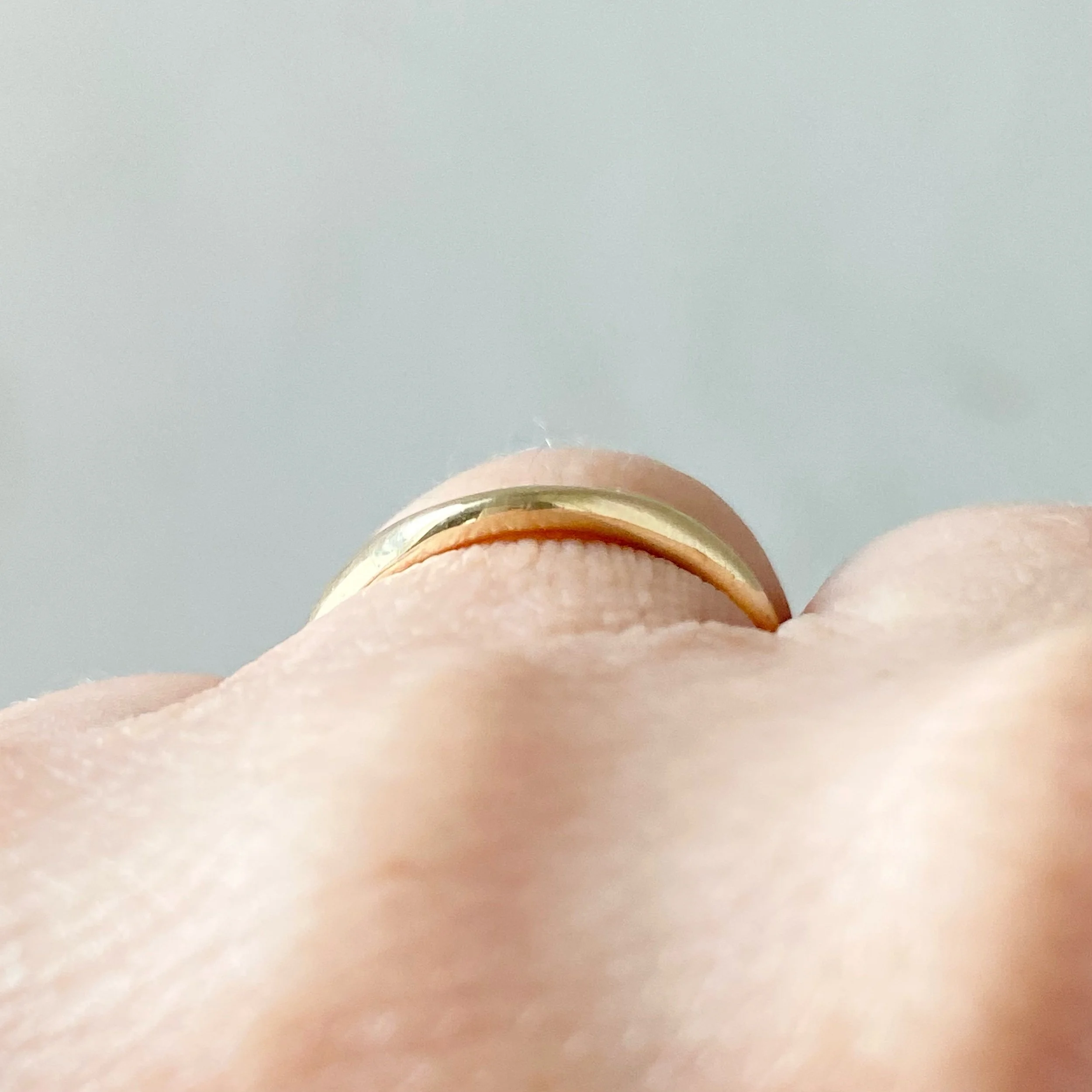 deep contour wedding ring 14k yellow recycled gold modern curved on hand through view kim drosdick toronto
