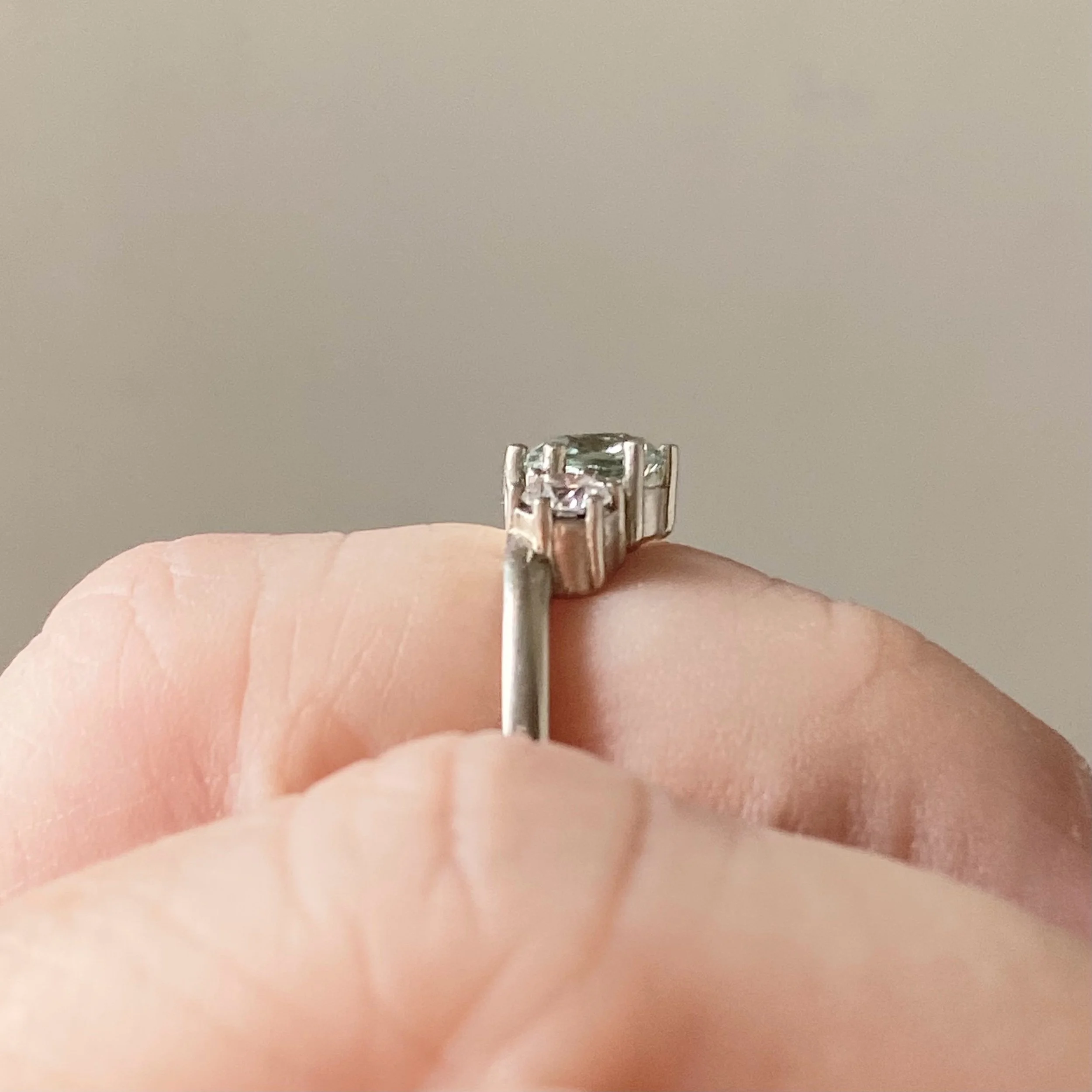 bette davis ring minty green lab grown sapphire with side ab diamonds flush edge engagement ring 14k recycled white gold through finger view on hand Kim Drosdick custom Jewellery