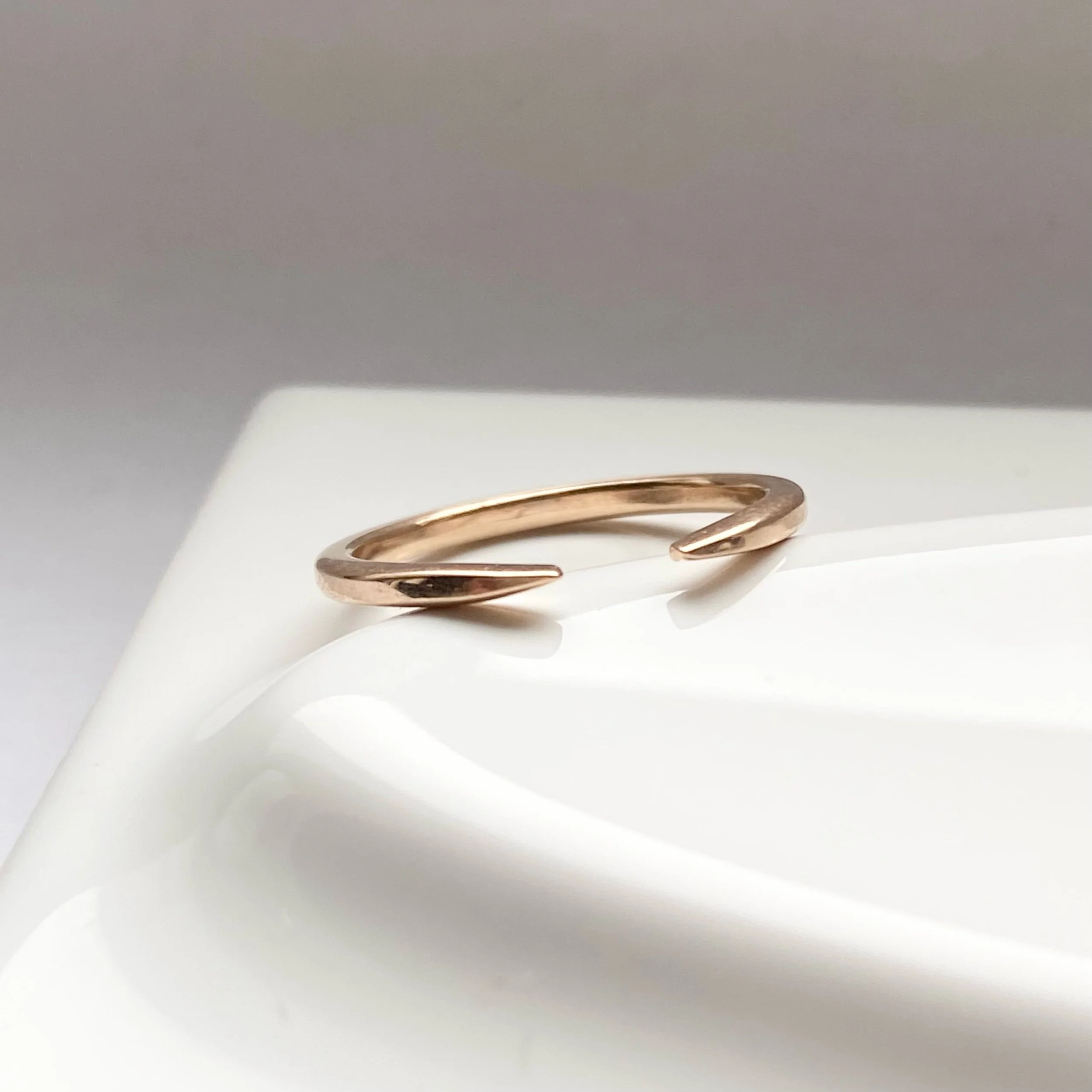 open design wedding stacking ring 14k recycled rose gold rounded narrow band on dish Kim Drosdick Toronto