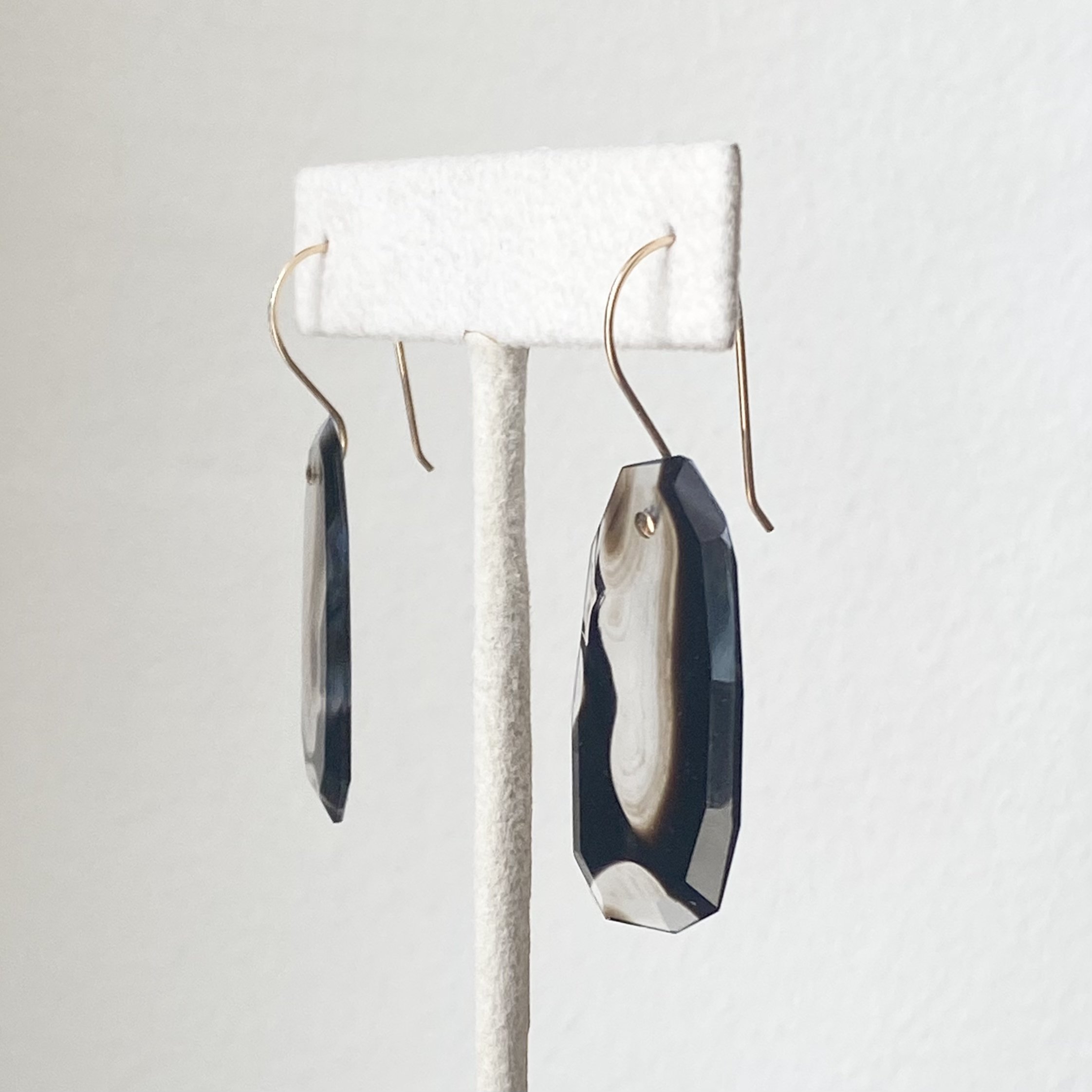 black agate colour banded transparent earthy hues dangly faceted earrings Kim Drosdick Toronto on stand side view
