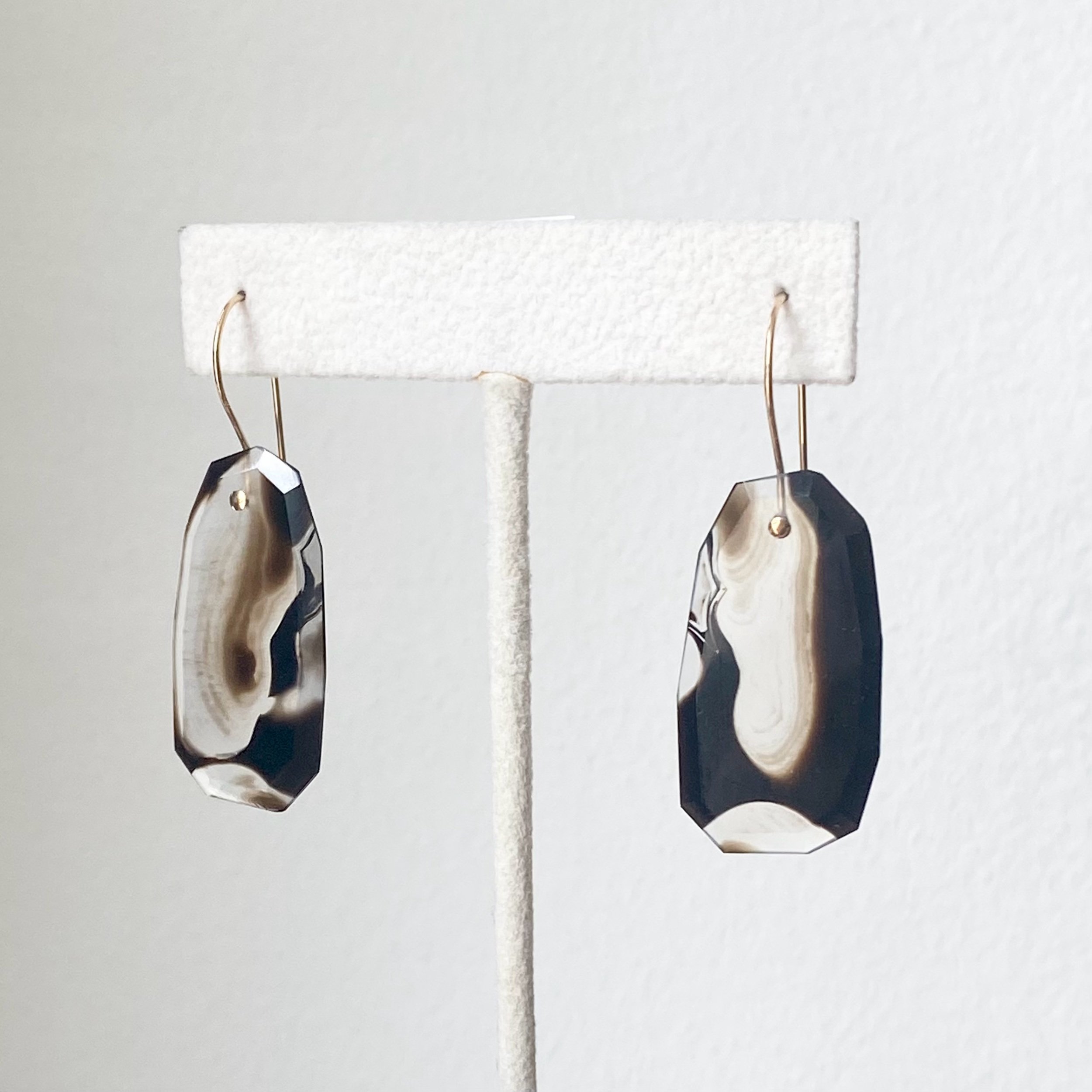 black agate colour banded transparent earthy hues dangly faceted earrings Kim Drosdick Toronto on stand side view