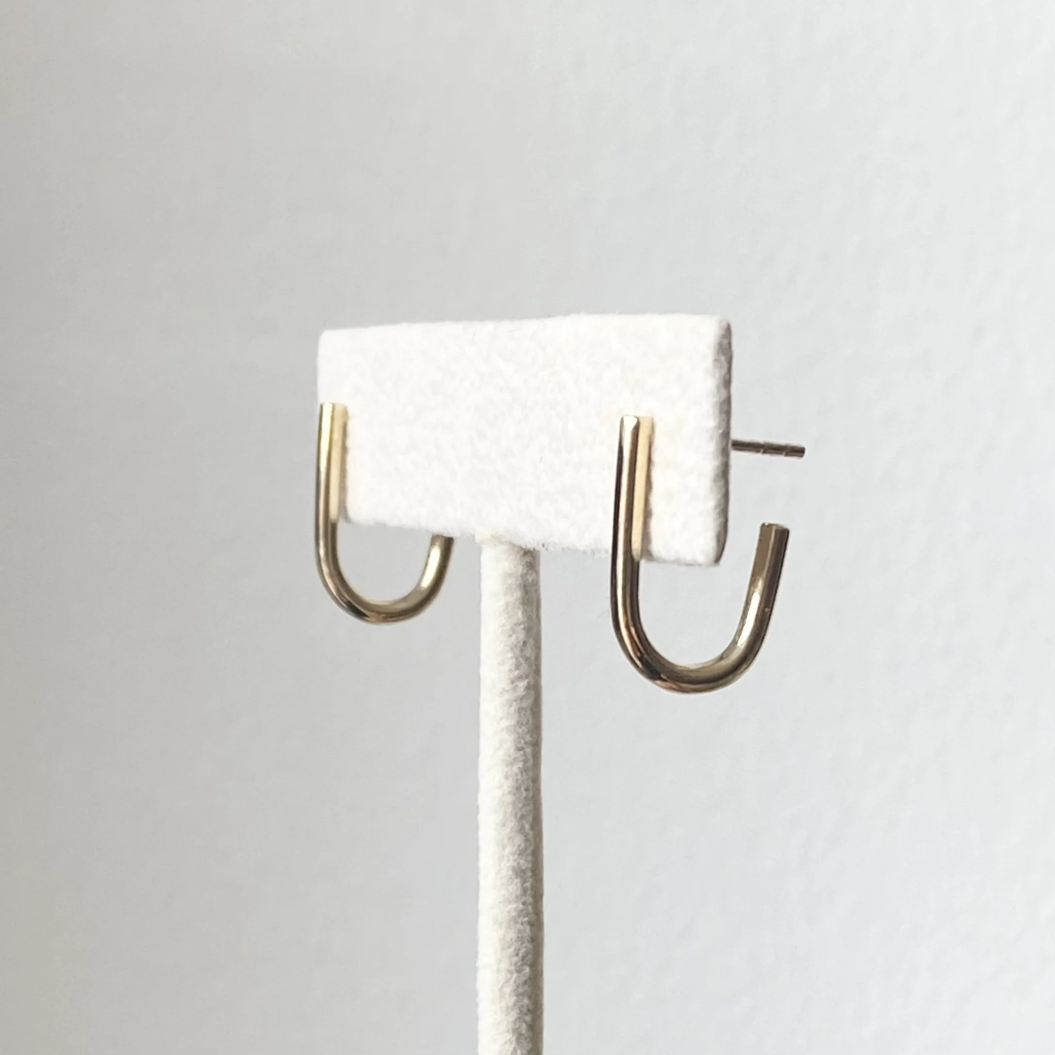 recycled 14k yellow gold round wire j hoop earrings on stand polished studs detail side view Kim Drosdick Jewellery Toronto