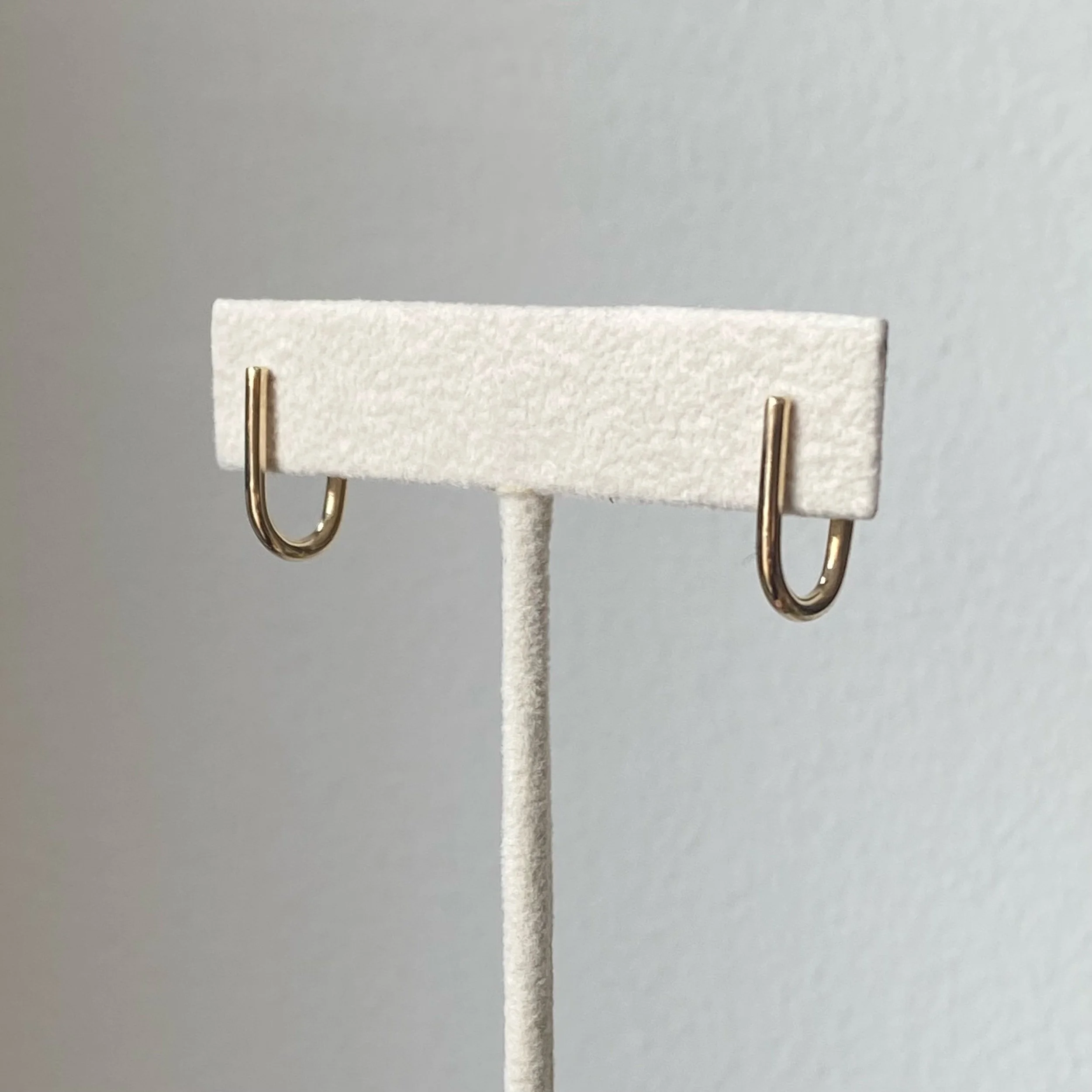 recycled 14k yellow gold round wire j hoop earrings on stand polished studs front view Kim Drosdick Jewellery Toronto
