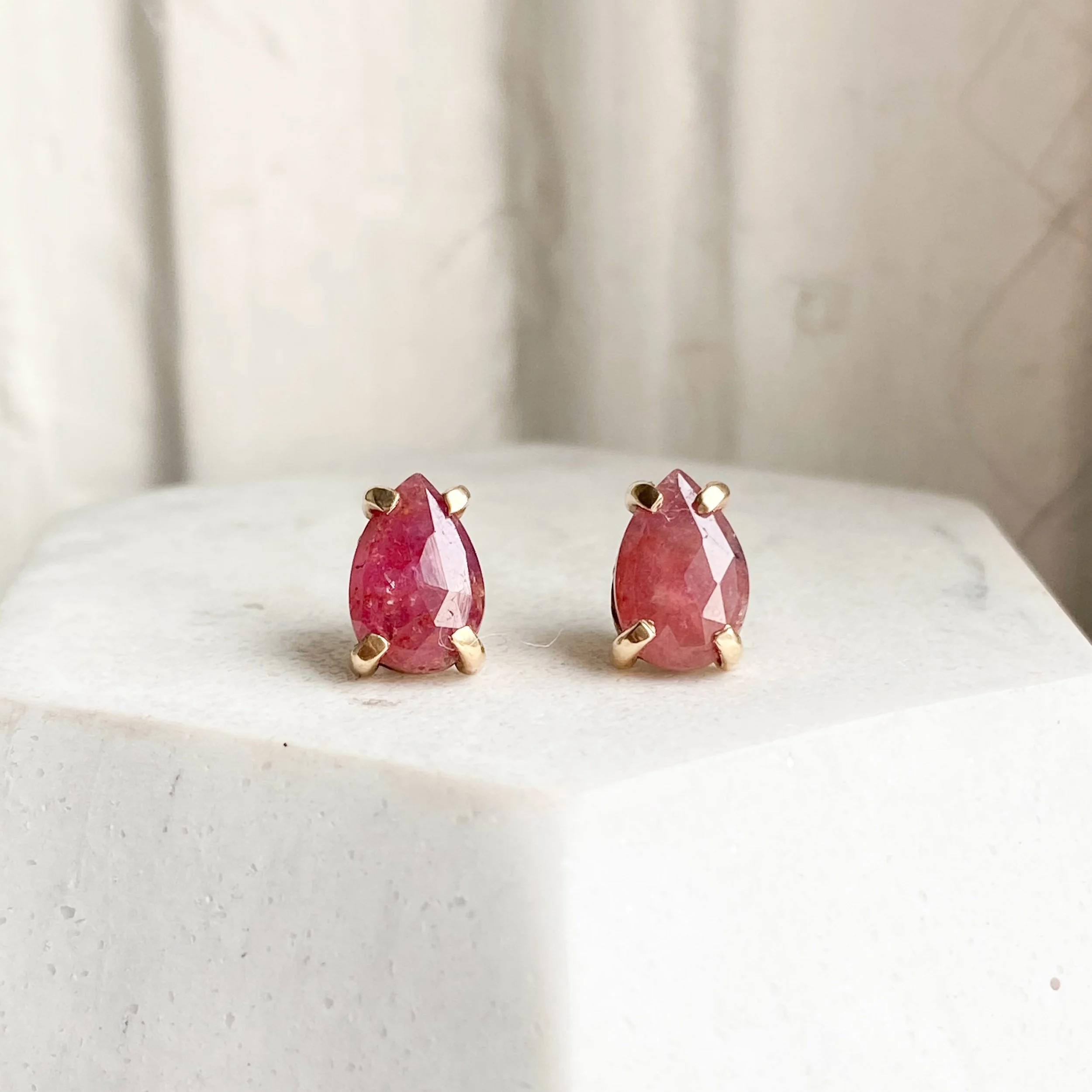 ruby rose cut pear studs in 14k yellow gold claw setting made by Kim Drosdick Toronto shown on display