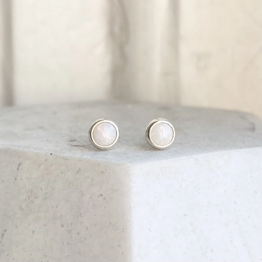 round white opal bezel set stud earrings made by Kim Drosdick in Toronto on display