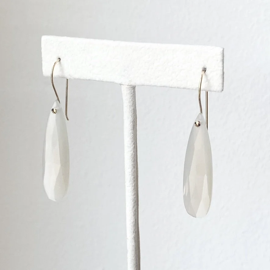 long faceted teardrop moonstone drop earrings with gold filled findings made by Kim Drosdick shown on earring stand