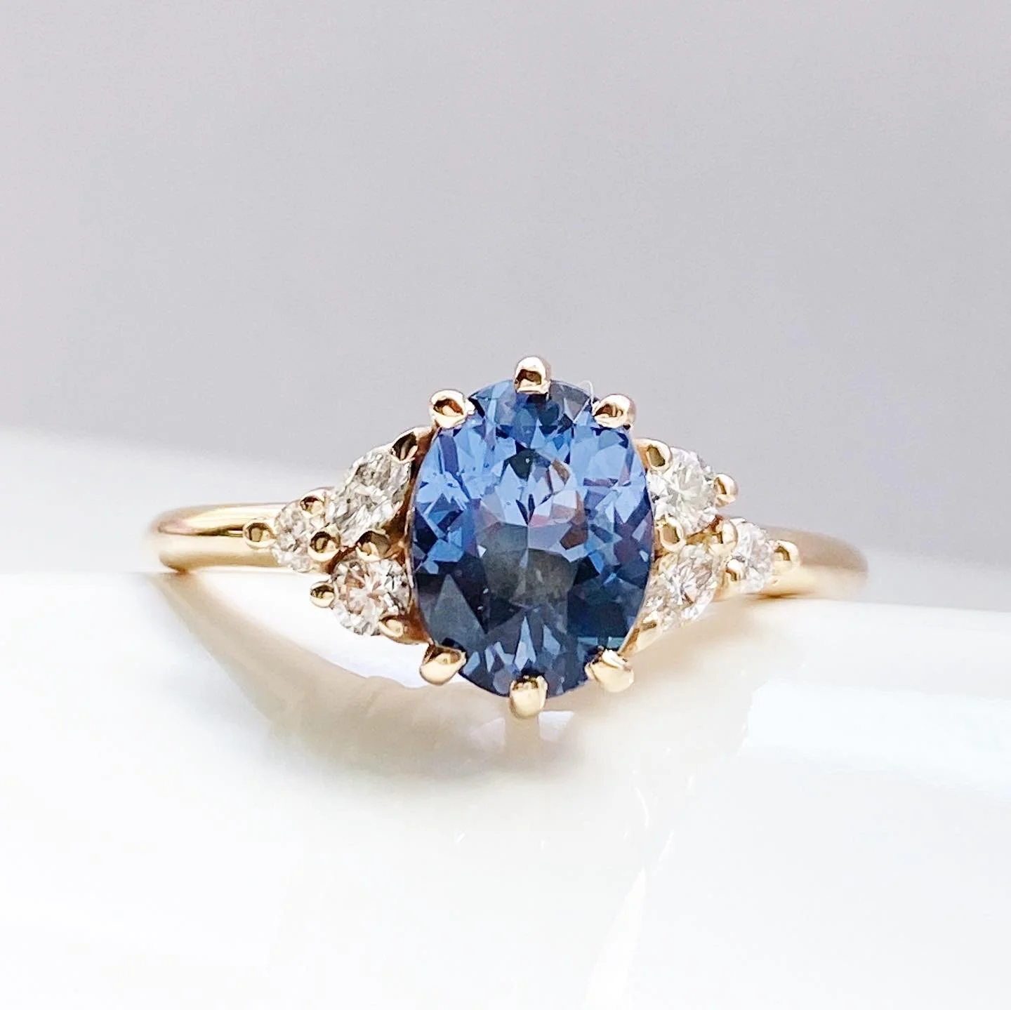 oval blue violet spinel diamond accents mirrored side clusters 14k yellow gold engagement ring Kim Drosdick Jewellery