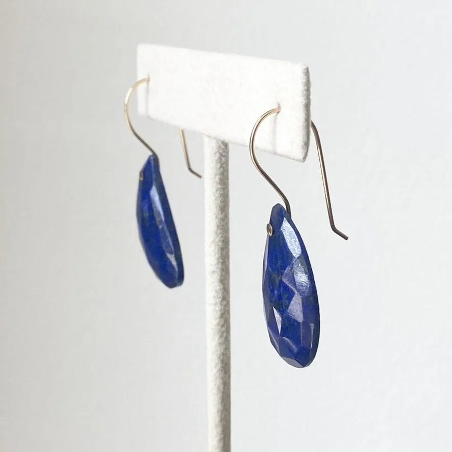 lapis lazuli faceted organic tear shape earrings with gold filled findings made by Kim Drosdick in Toronto shown on earring stand side view