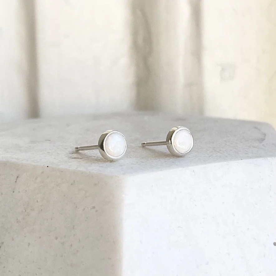 round white opal bezel set stud earrings made by Kim Drosdick in Toronto on display side view