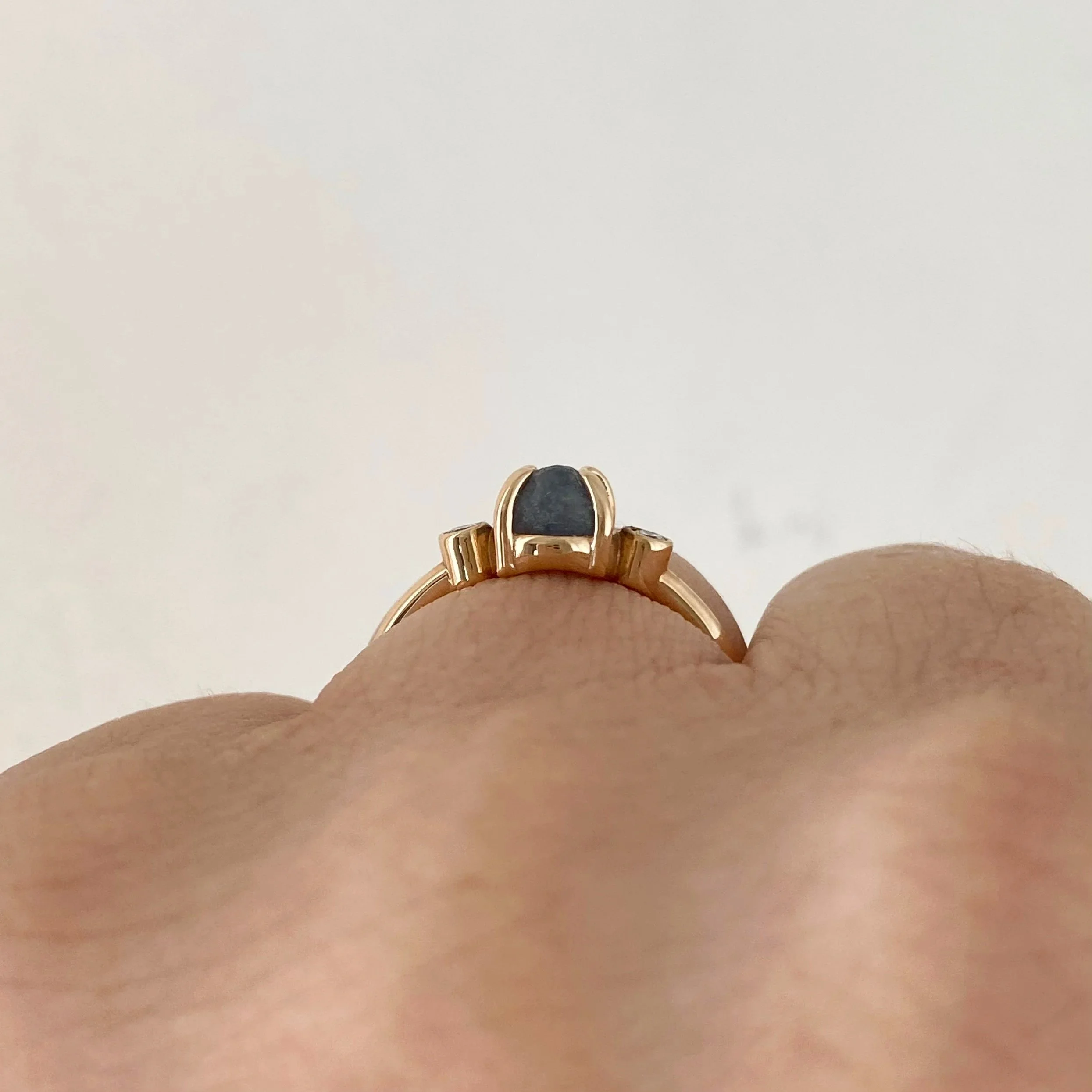 rough blue montana engagement ring claw set and bezel set side canadian diamonds 14k yellow gold through finger view on hand Kim Drosdick Jewellery Toronto