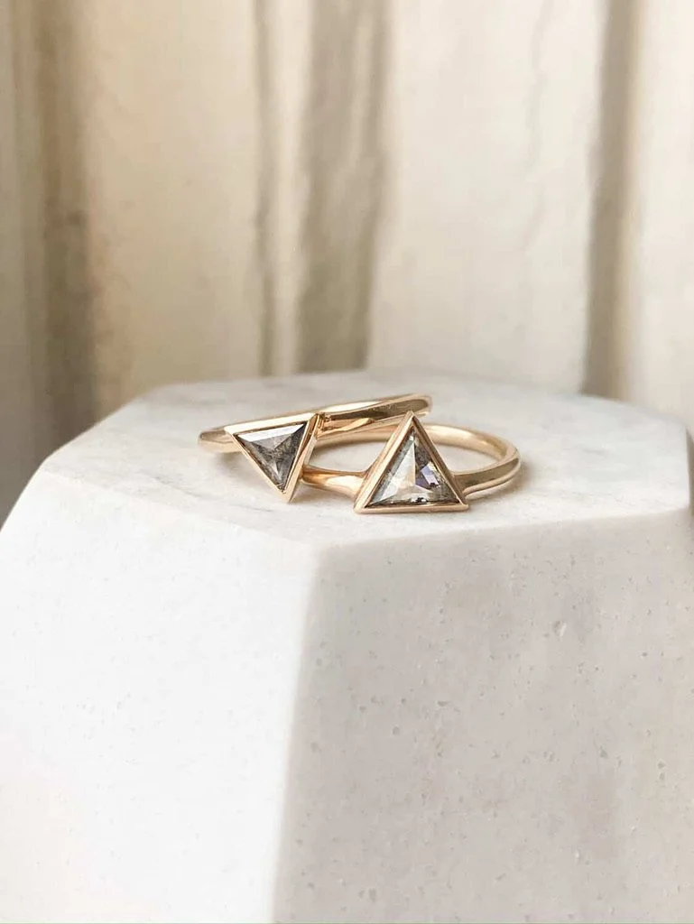darker triangle salt and pepper diamond bezel set off side bottom justified to round wire band 14k yellow gold front view on prop dish Kim Drosdick Jewellery Toronto